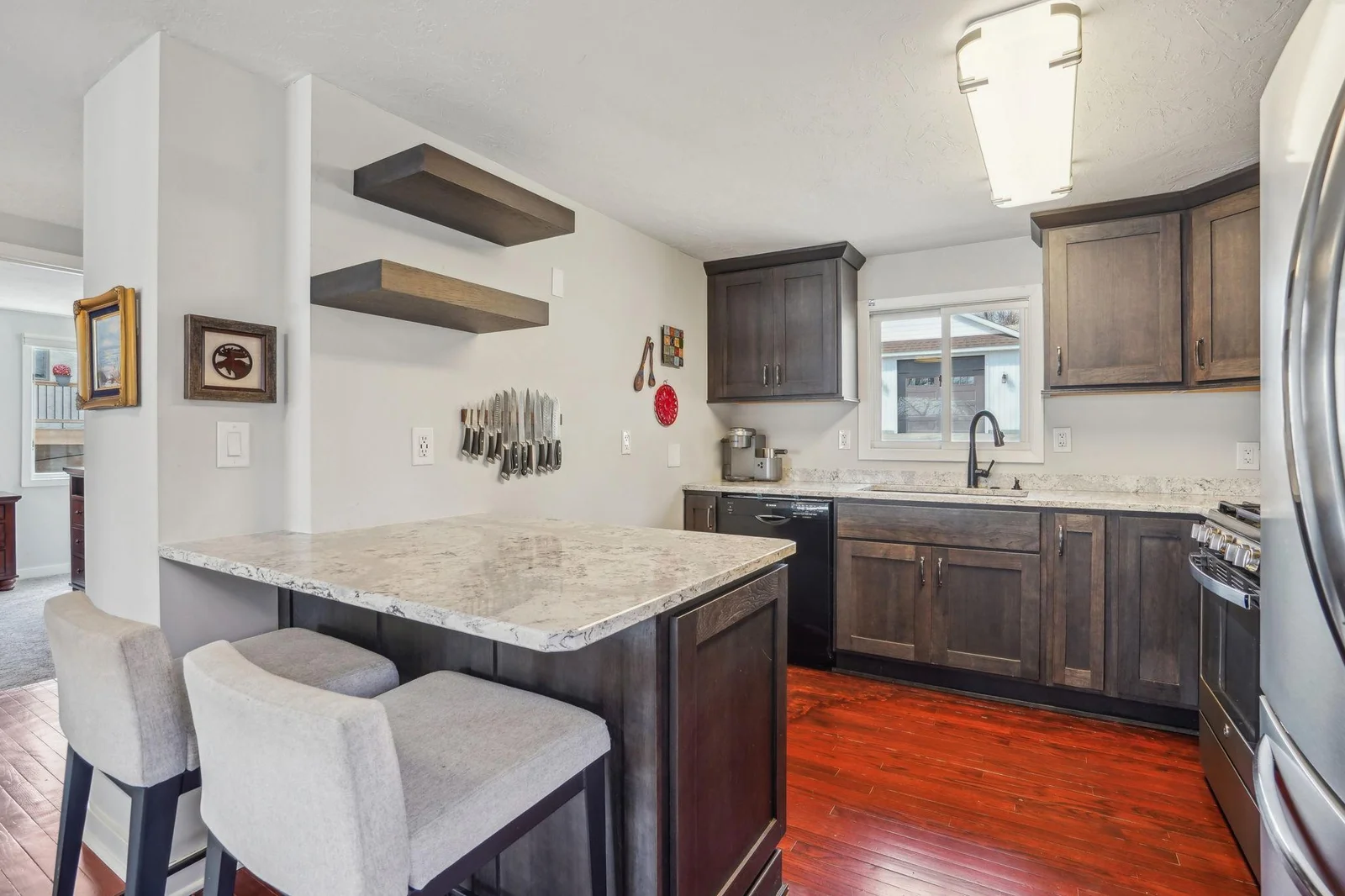 Stainless steel appliances are complemented by dark cabinetry and light countertops, creating a sleek and modern aesthetic in the kitchen.