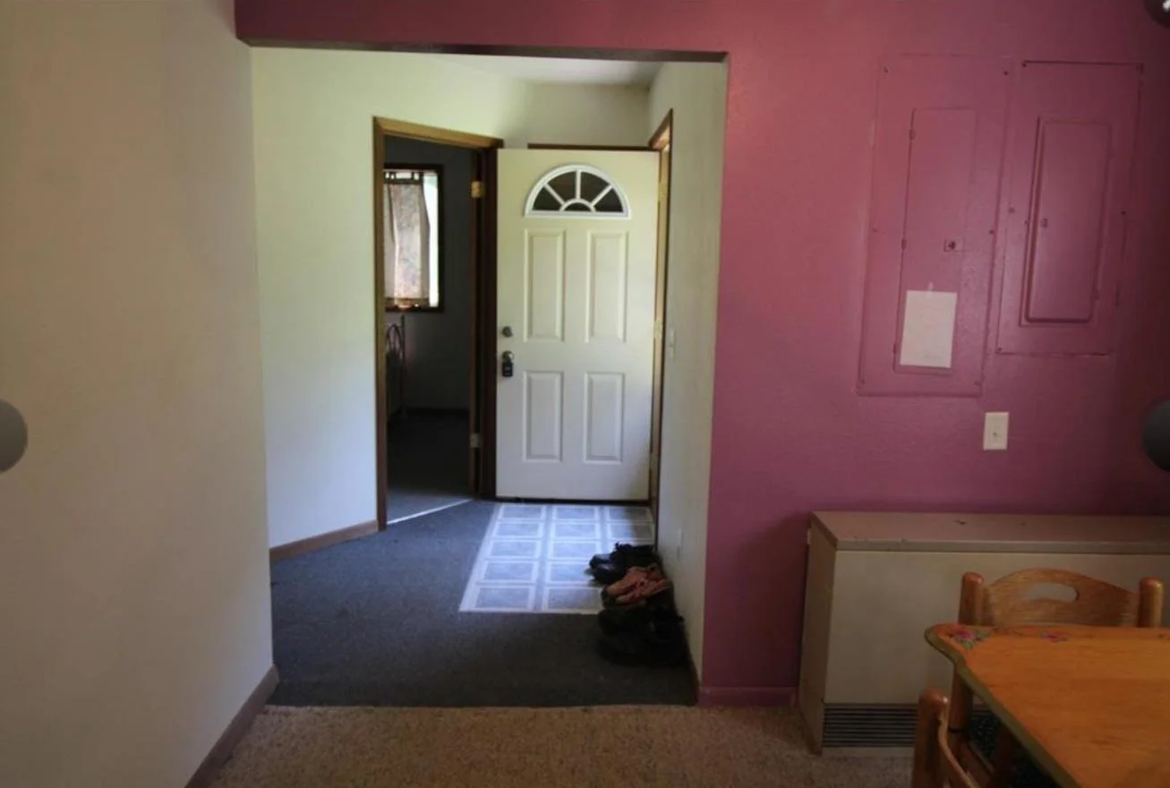 View from dining area to the side door and a bedroom.
