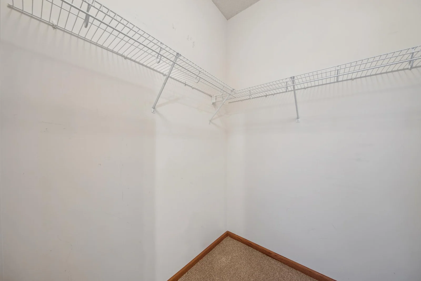 Spacious walk in closet with built in shelving.