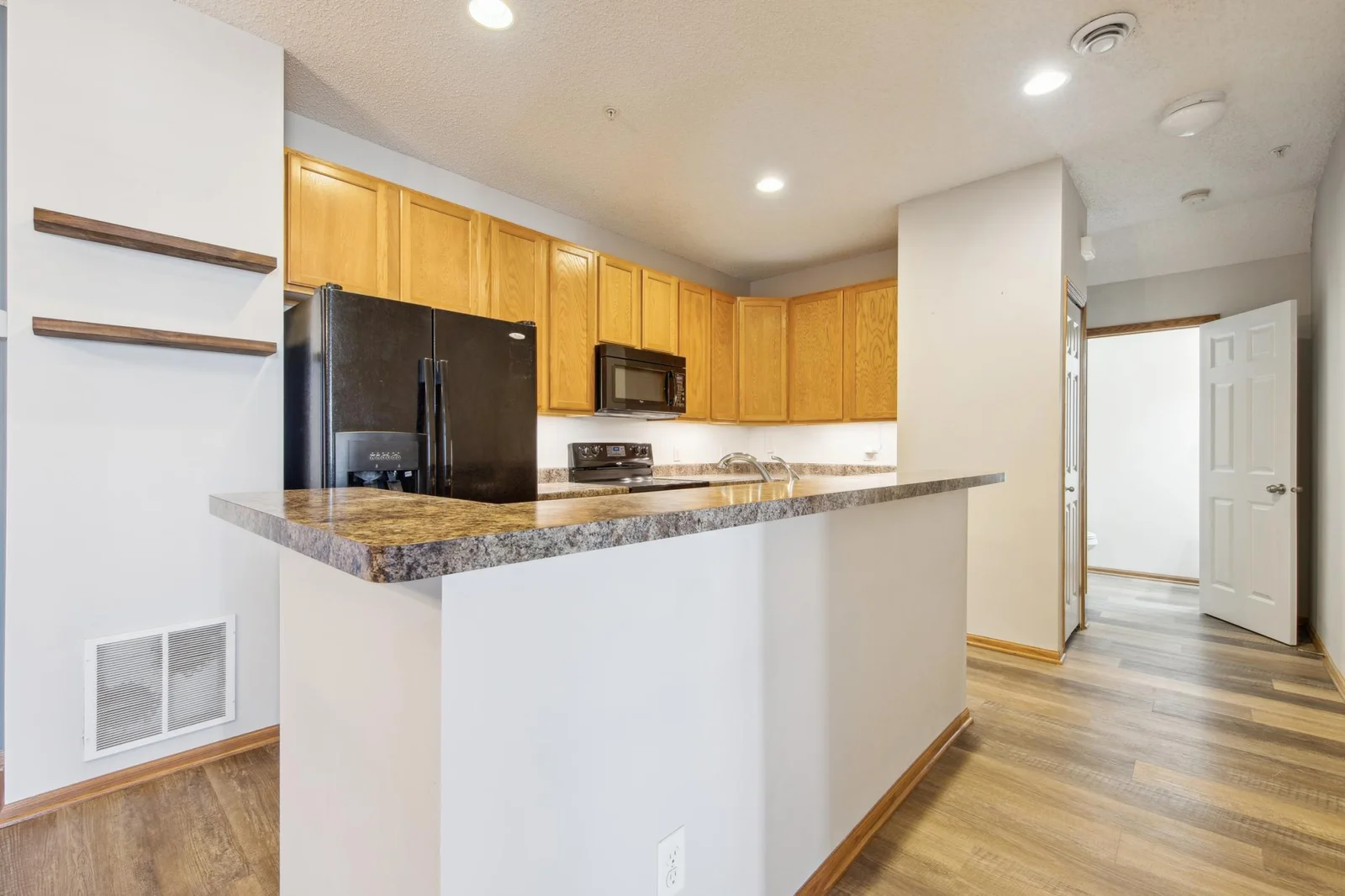 Entertaining main level kitchen with gleaming vinyl plank flooring throughout.