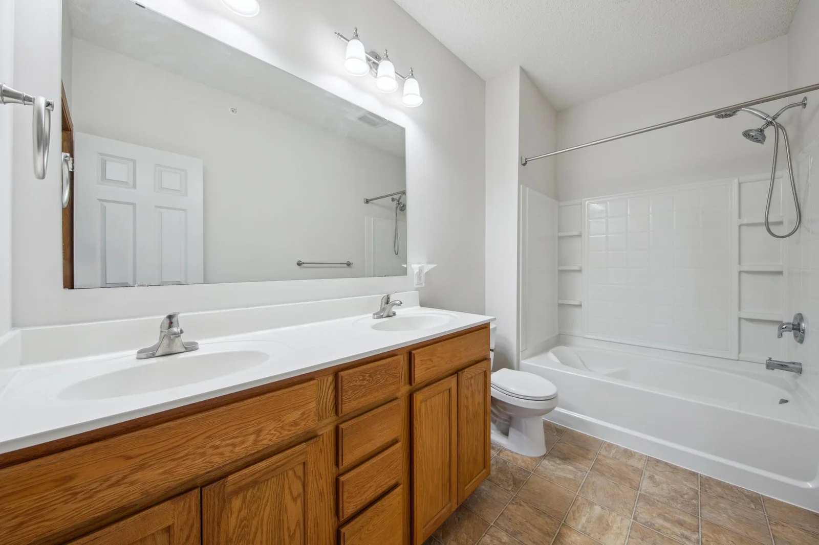 Private owners suite full bathroom with a large double vanity and built in shower shelving.