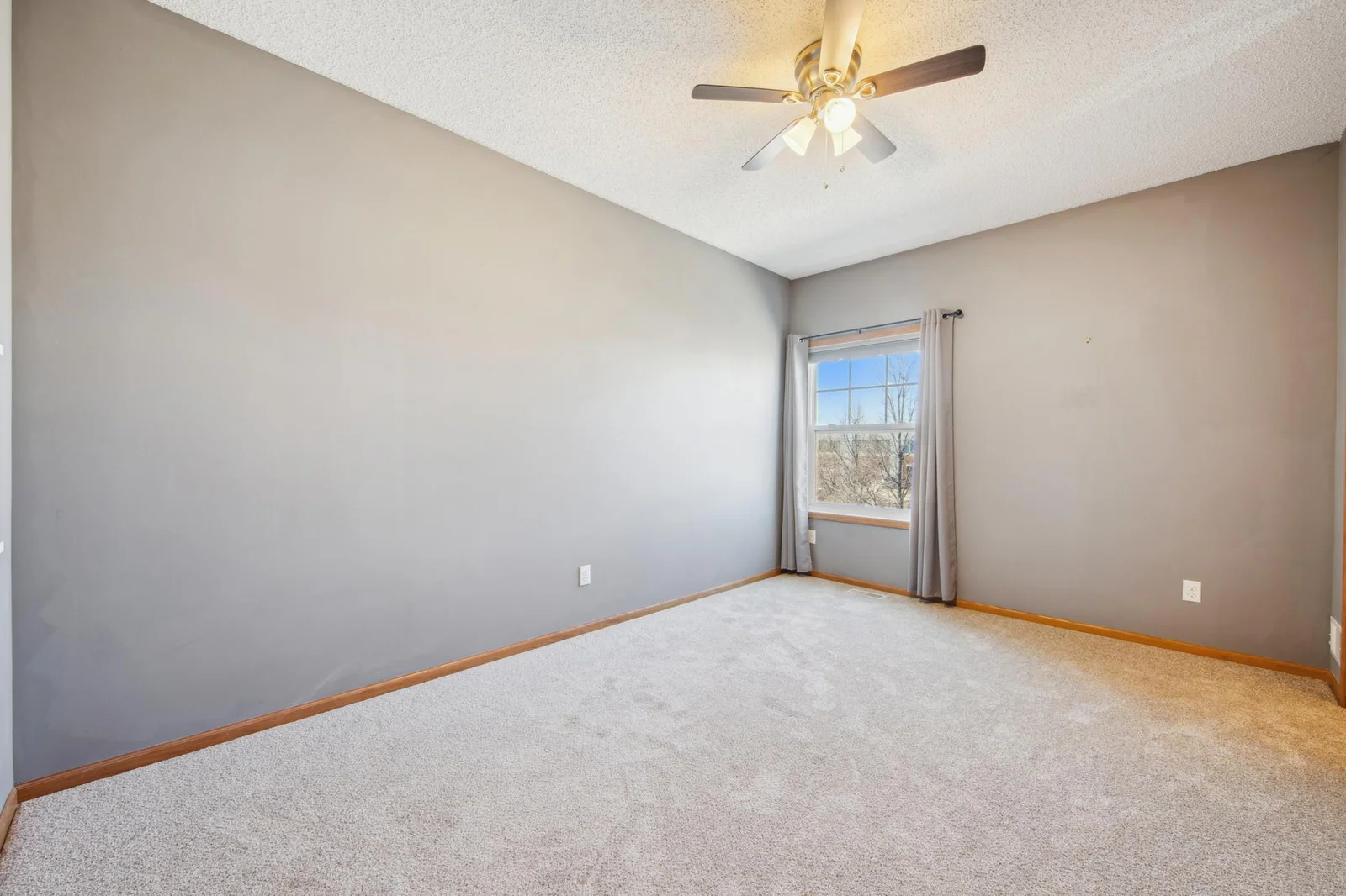 1st upper level bedroom with new carpet, large ceiling fan and ample natural light.