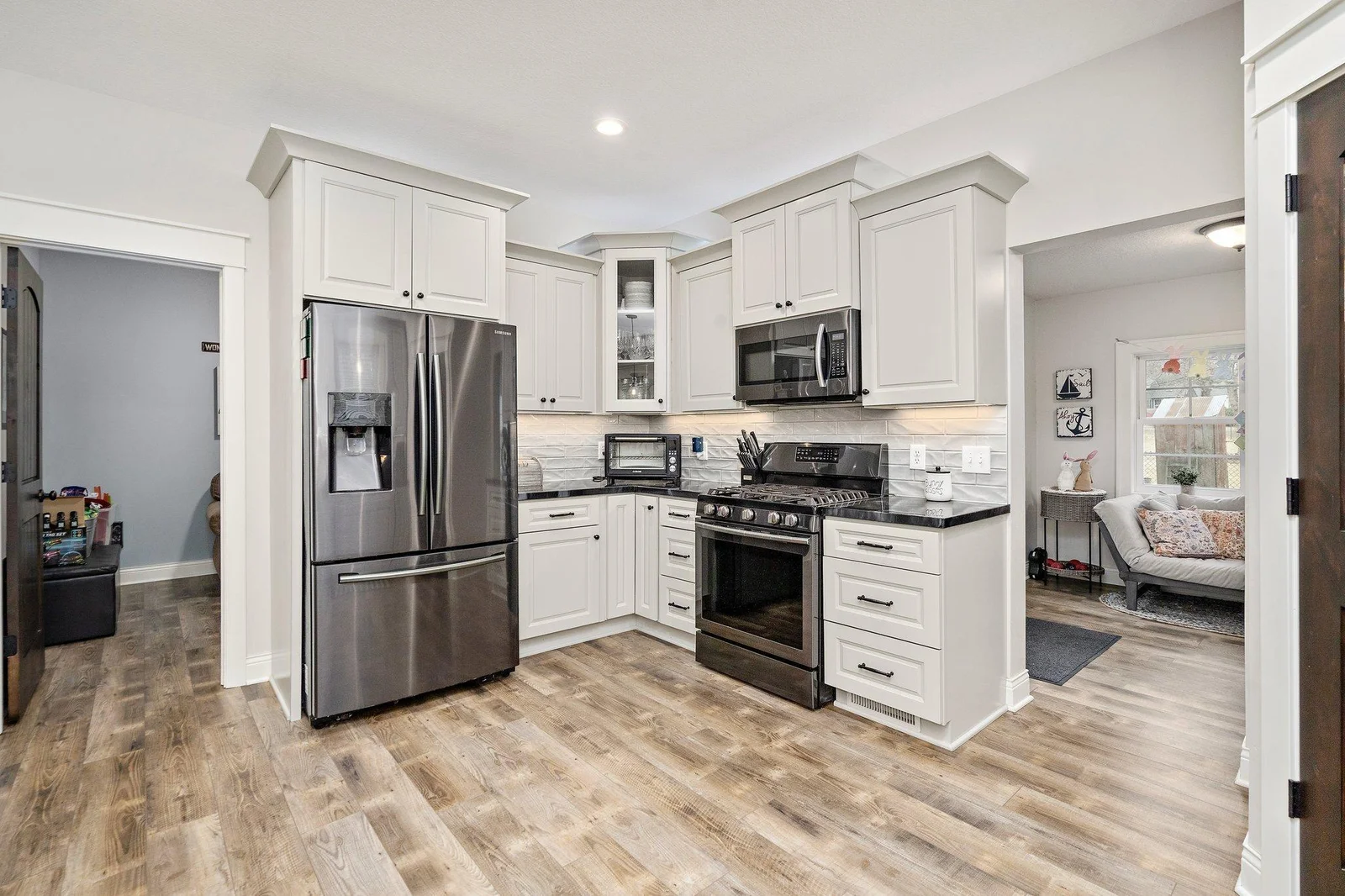 Beautiful kitchen featuring black stainless steel (sometimes called “clean steel”) appliances, ample cabinet and counter space with soft close doors and drawers, and attractive backsplash!