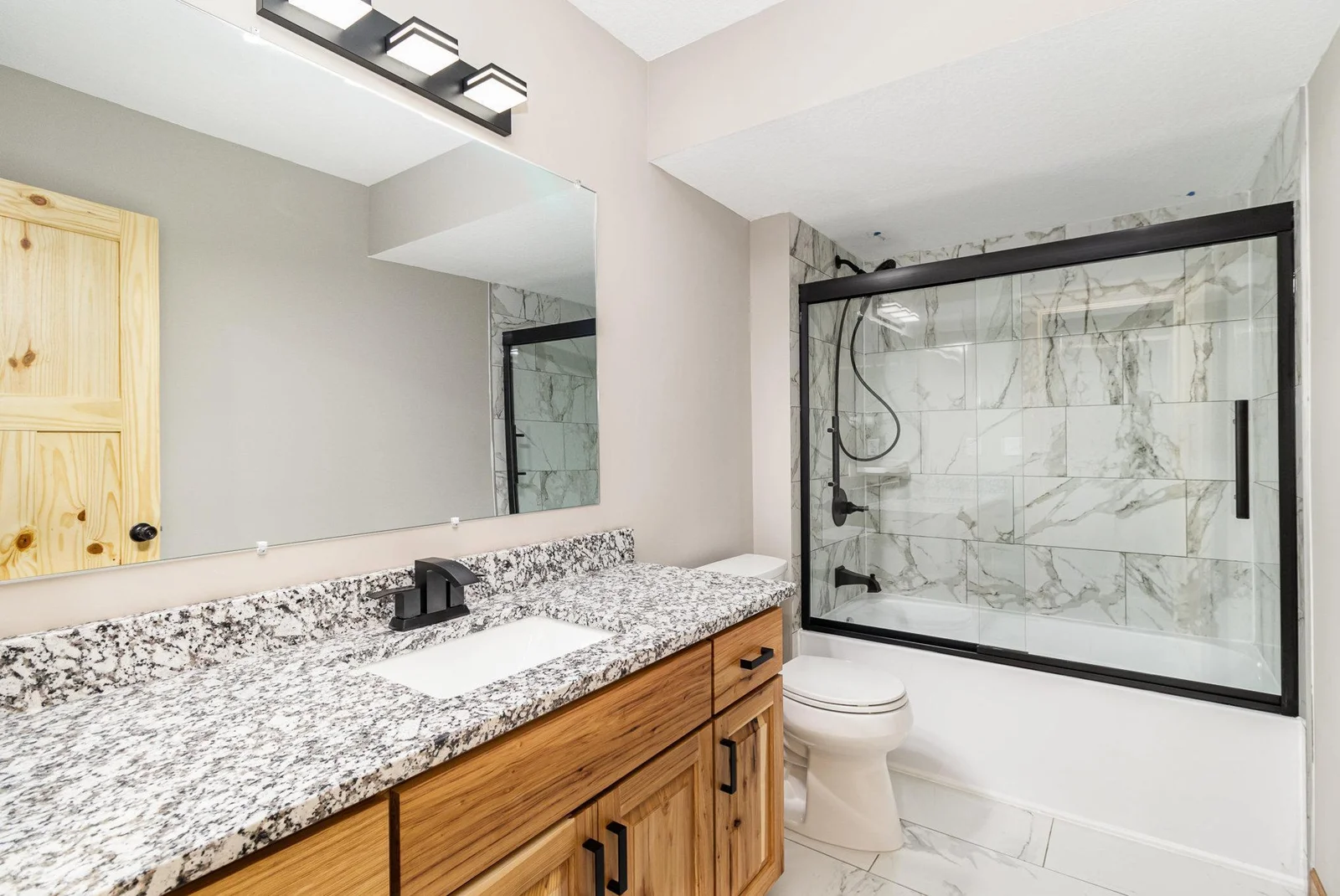 Lower Level Bathroom, with beautiful finishes including custom tiled bath surround.