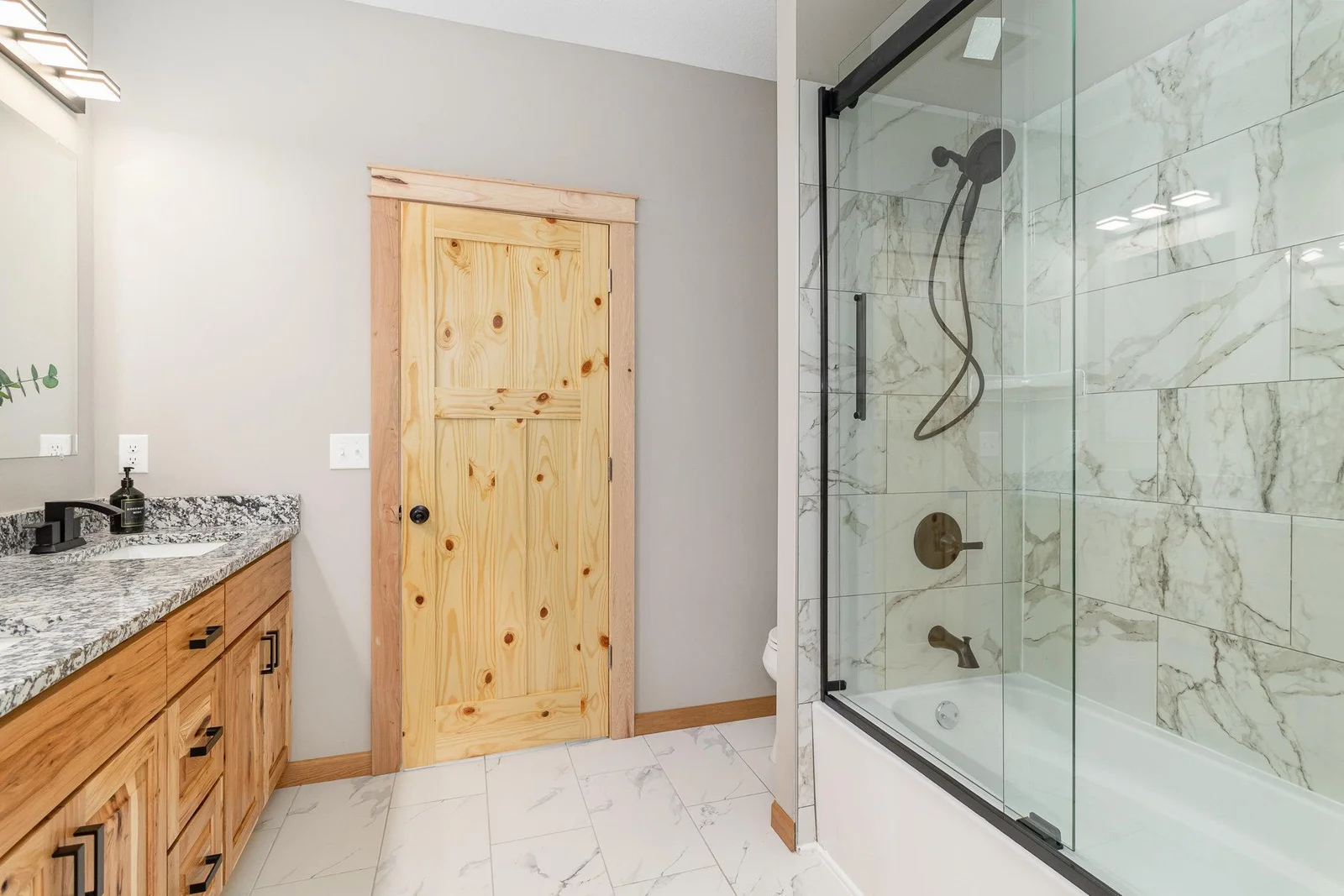 The countertops and cabinets are consistent in all 3 bathrooms and kitchen.  Custom tile work in bath surround.