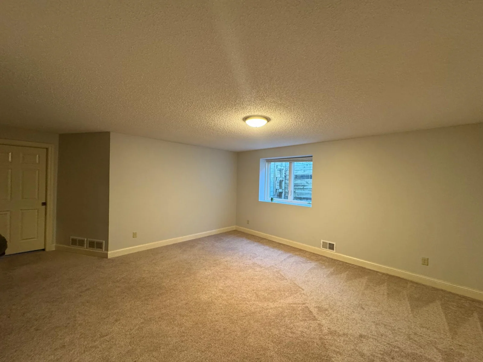 Basement family room with french doors & adjacent 4th bedroom..