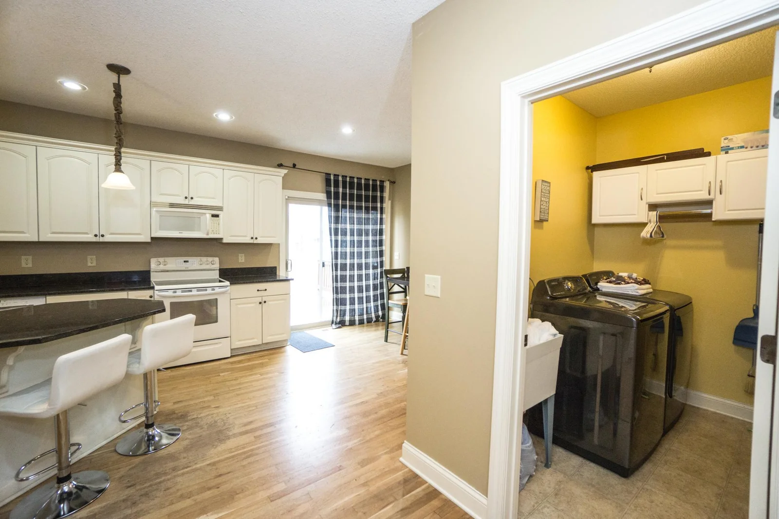 Main floor laundry right off kitchen with newer washer and a utility sink..