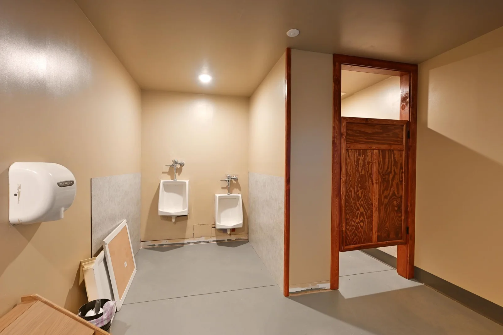The men’s bathroom has the capacity to service a large group and just needs your added touches.