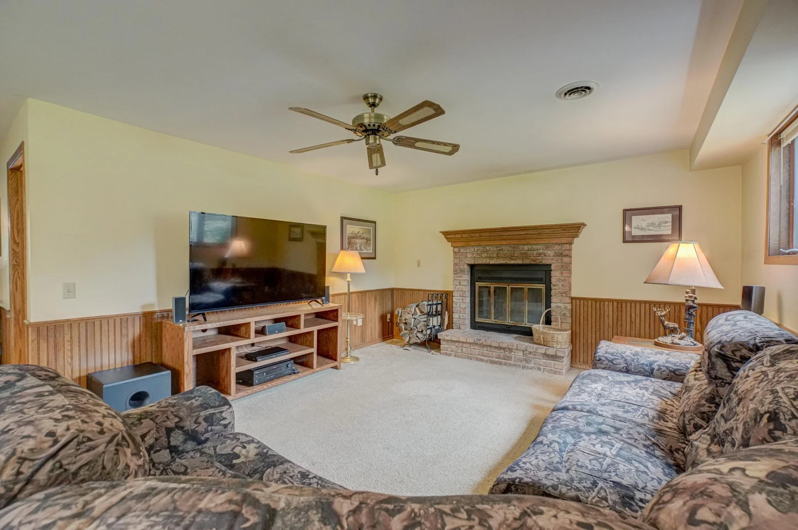 Downstairs, you’ll find two more bedrooms, a second living area with a cozy wood-burning fireplace, and excellent storage.