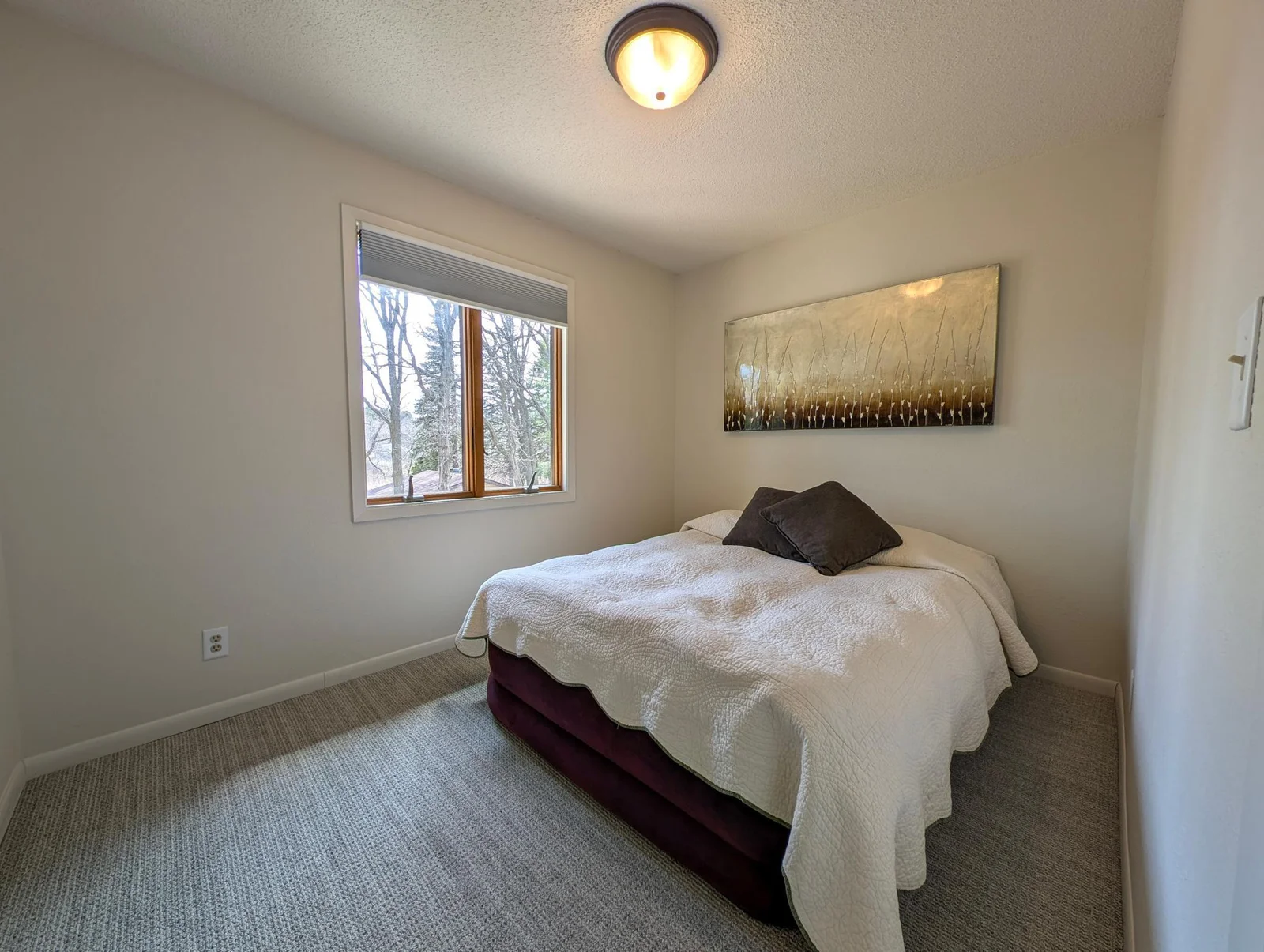 Peaceful main-floor bedroom with neutral tones and natural light—your private lakeside retreat.