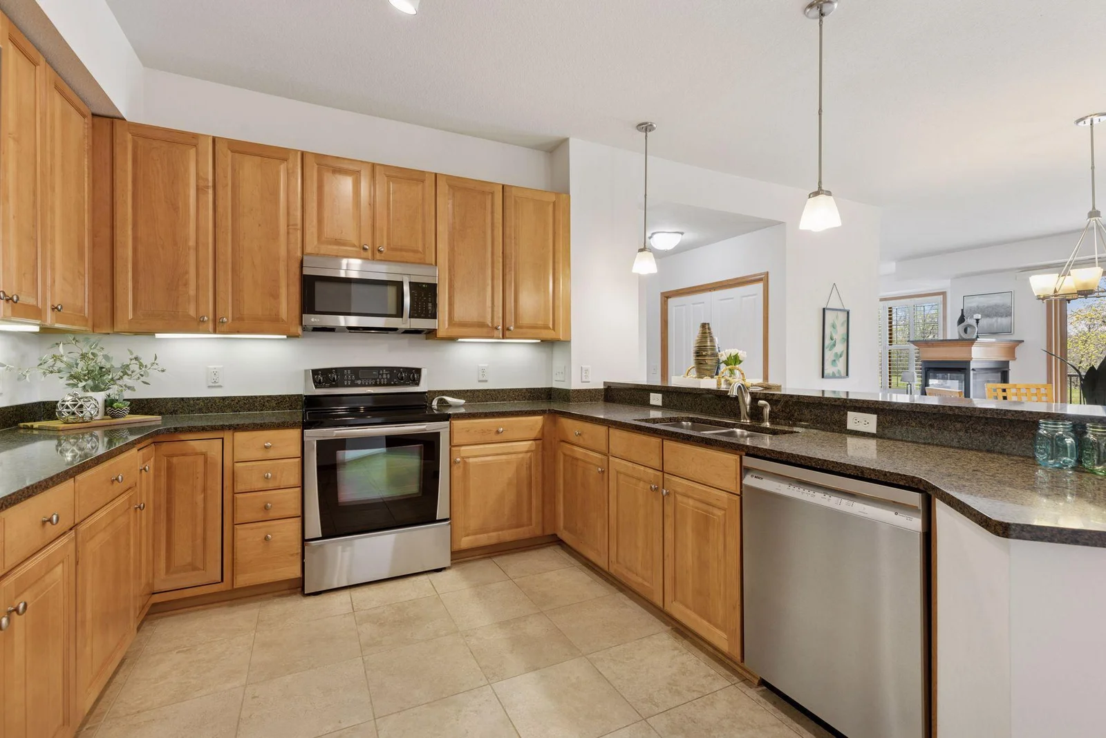 Open Kitchen with updated tile, granite countertops, stainless appliances, undermount lighting, and spectacular views!