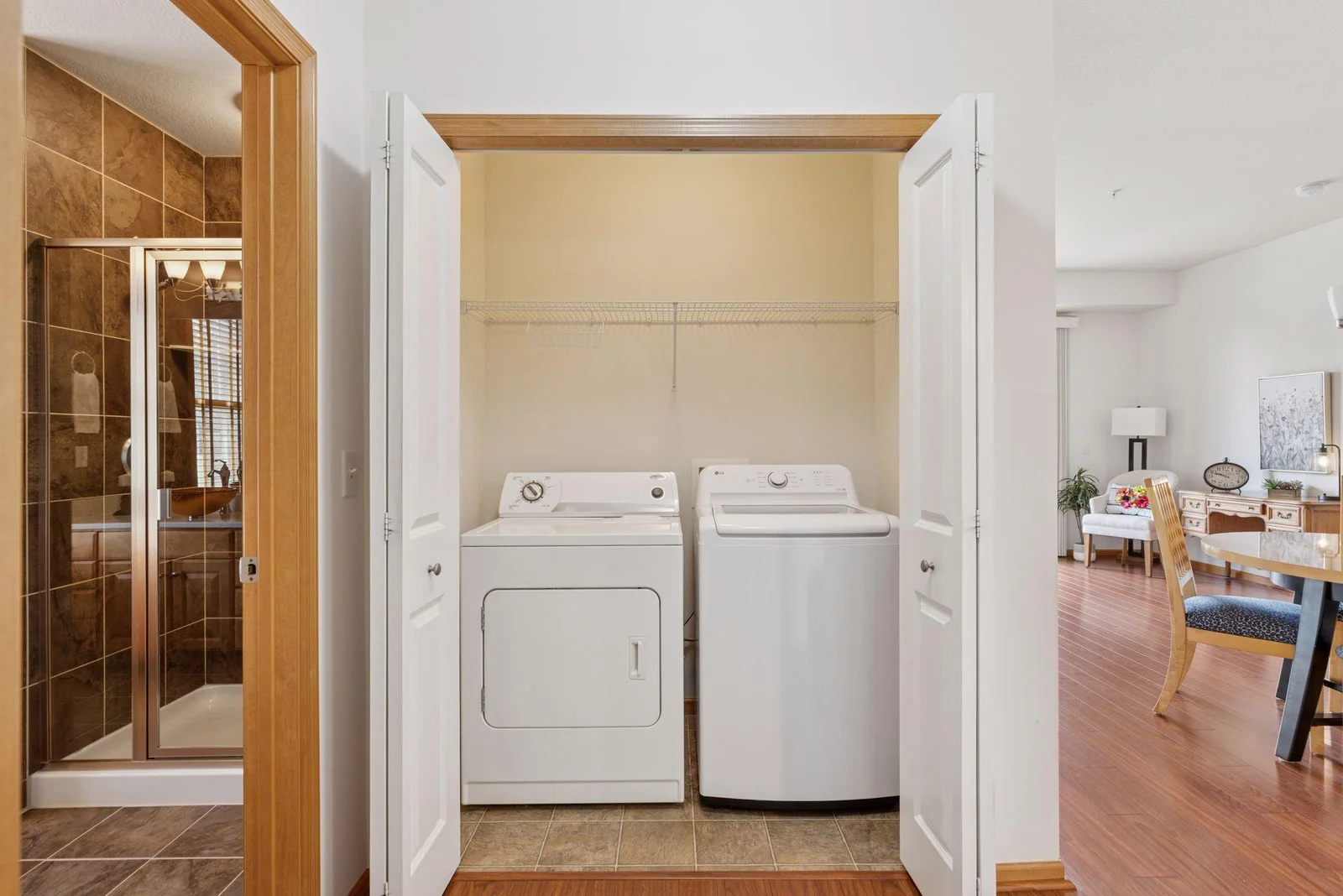 Laundry closet with built-in shelving is conveniently located.