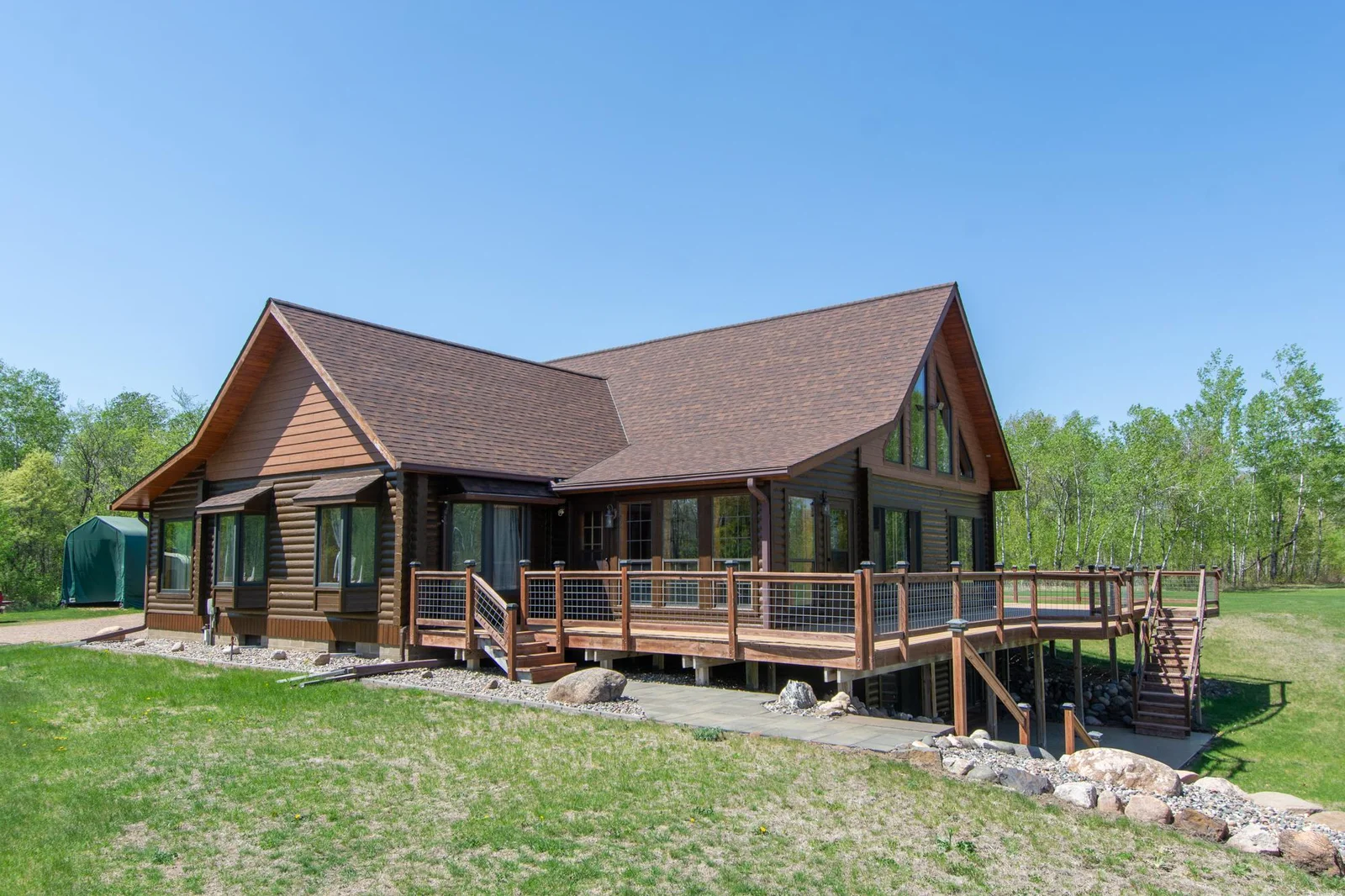 A view of the home and deck from the southeast . The deck overlooks the yard and mine pit lake.