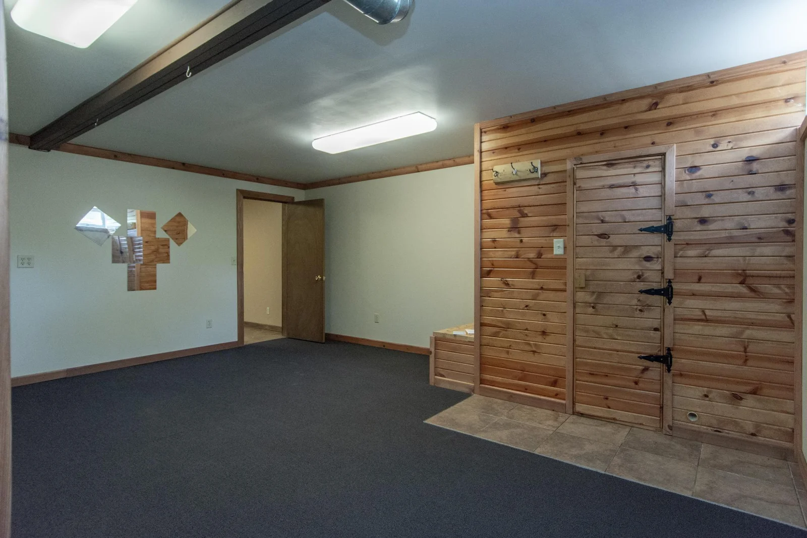 Bedroom or exercise room has a carpeted floor, a sauna, and a 5x18 space behind the south wall that is currently being used as a workspace or craft space.