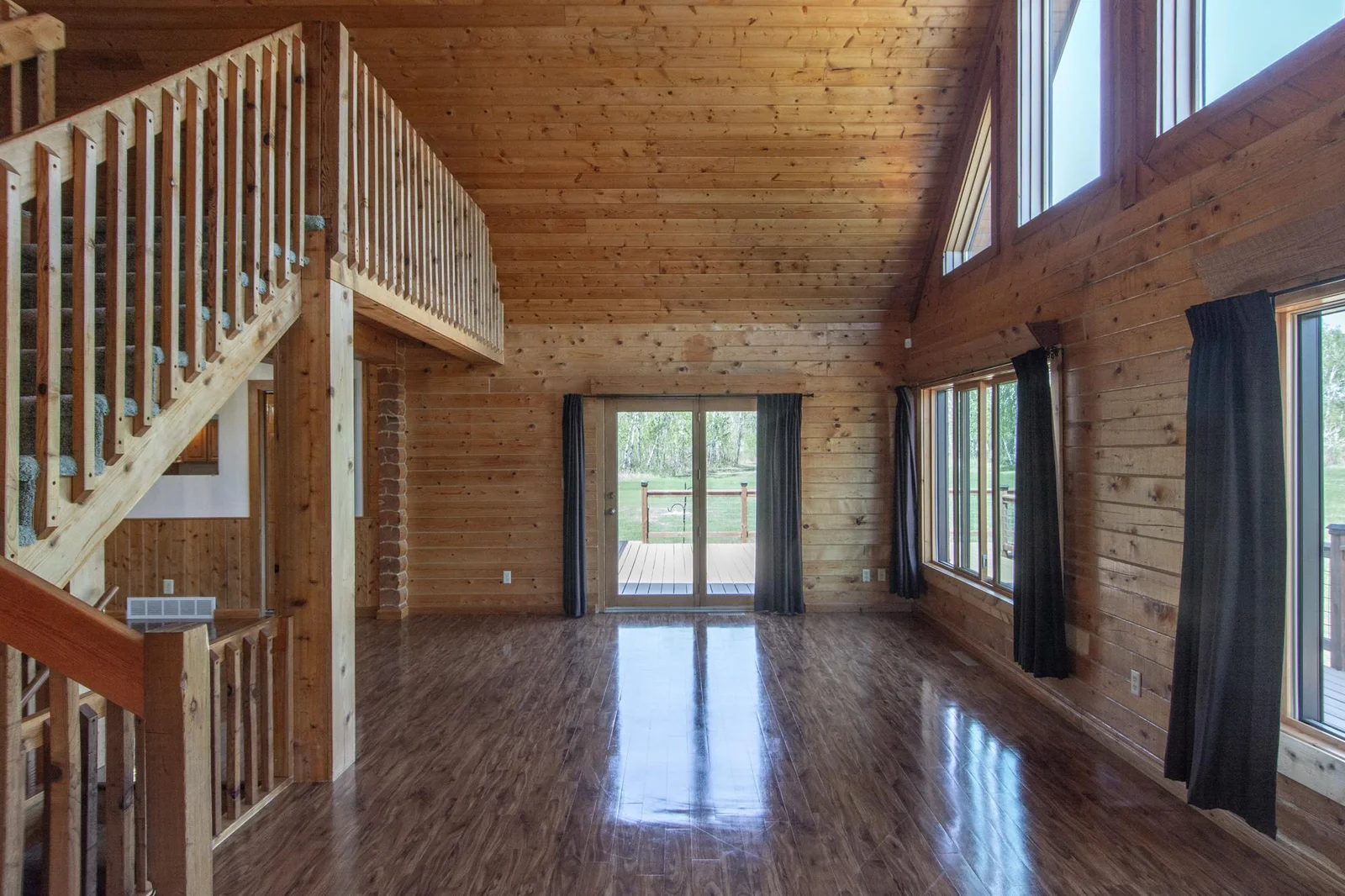 The Living Room has a vinyl floor, a ceiling fan, a 2x4 ft. closet, six east-facing windows, a north-facing patio door with deck access, and a south-facing door to the 3-season porch.