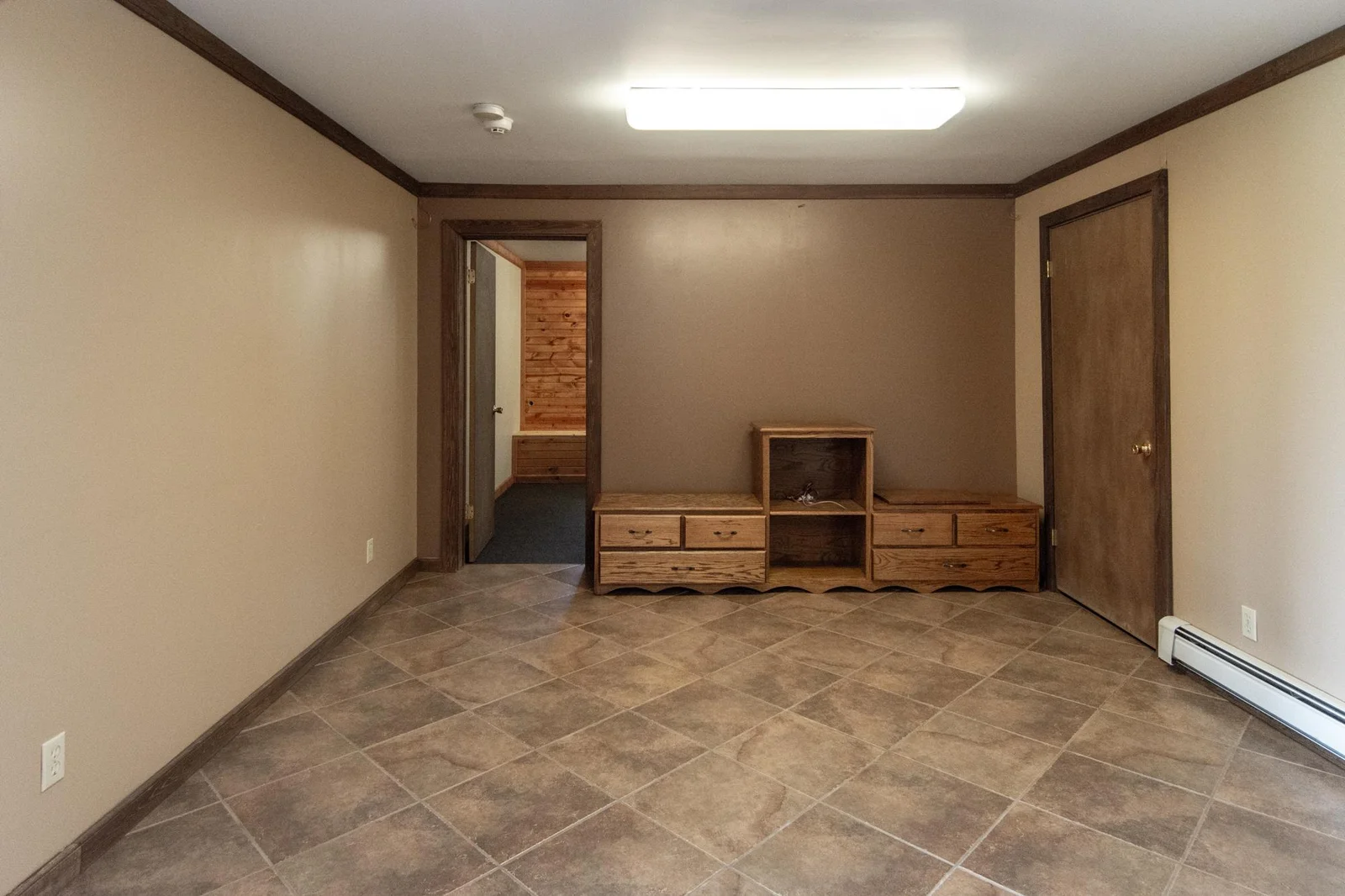 A view of the family room with doors leading to the bedroom or exercise/sauna room and the utility room.