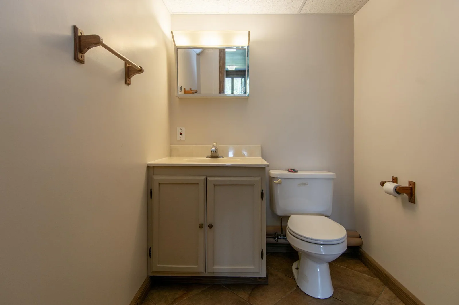 Lower-level half bathroom has a tile floor.