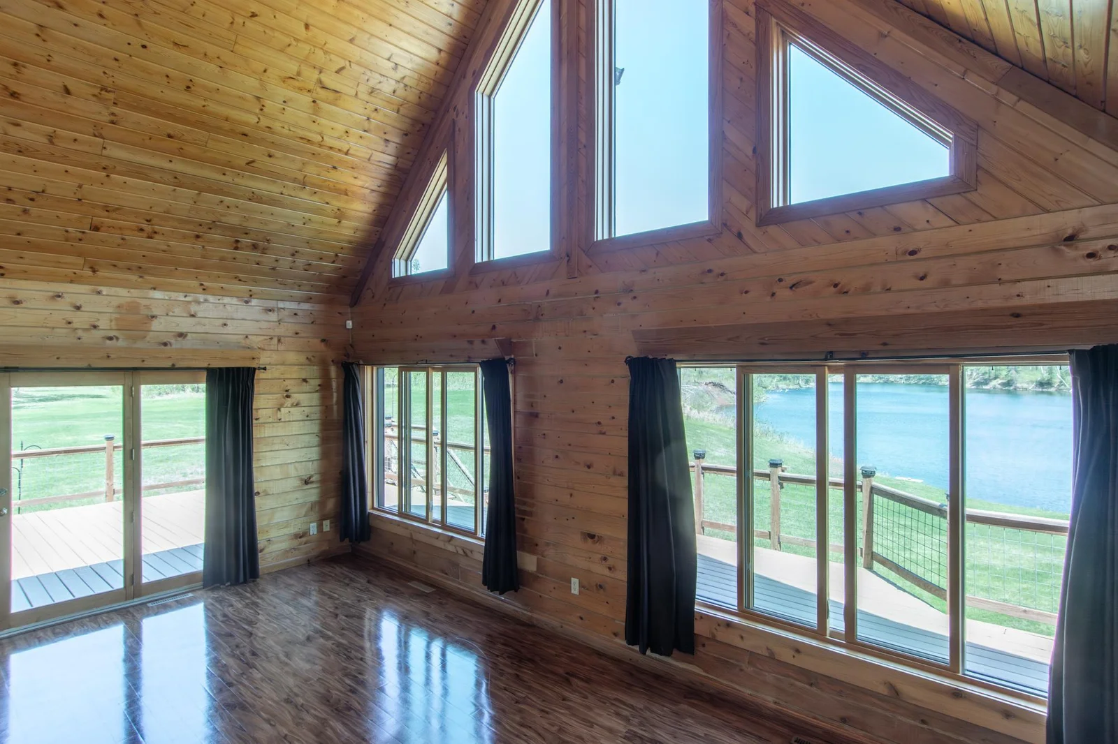 The Living Room has a vinyl floor, a ceiling fan, a 2x4 ft. closet, six east-facing windows, a north-facing patio door with deck access, and a south-facing door to the 3-season porch.
