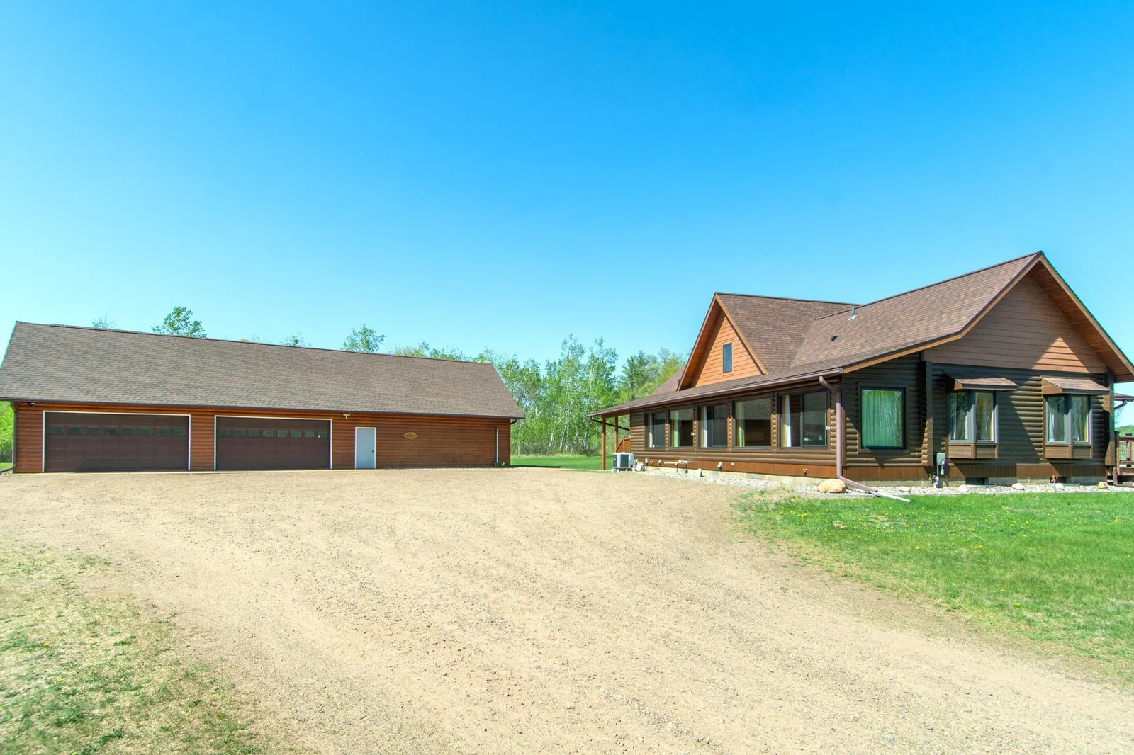A view of the home and 4-stall garage with a workshop from the driveway.