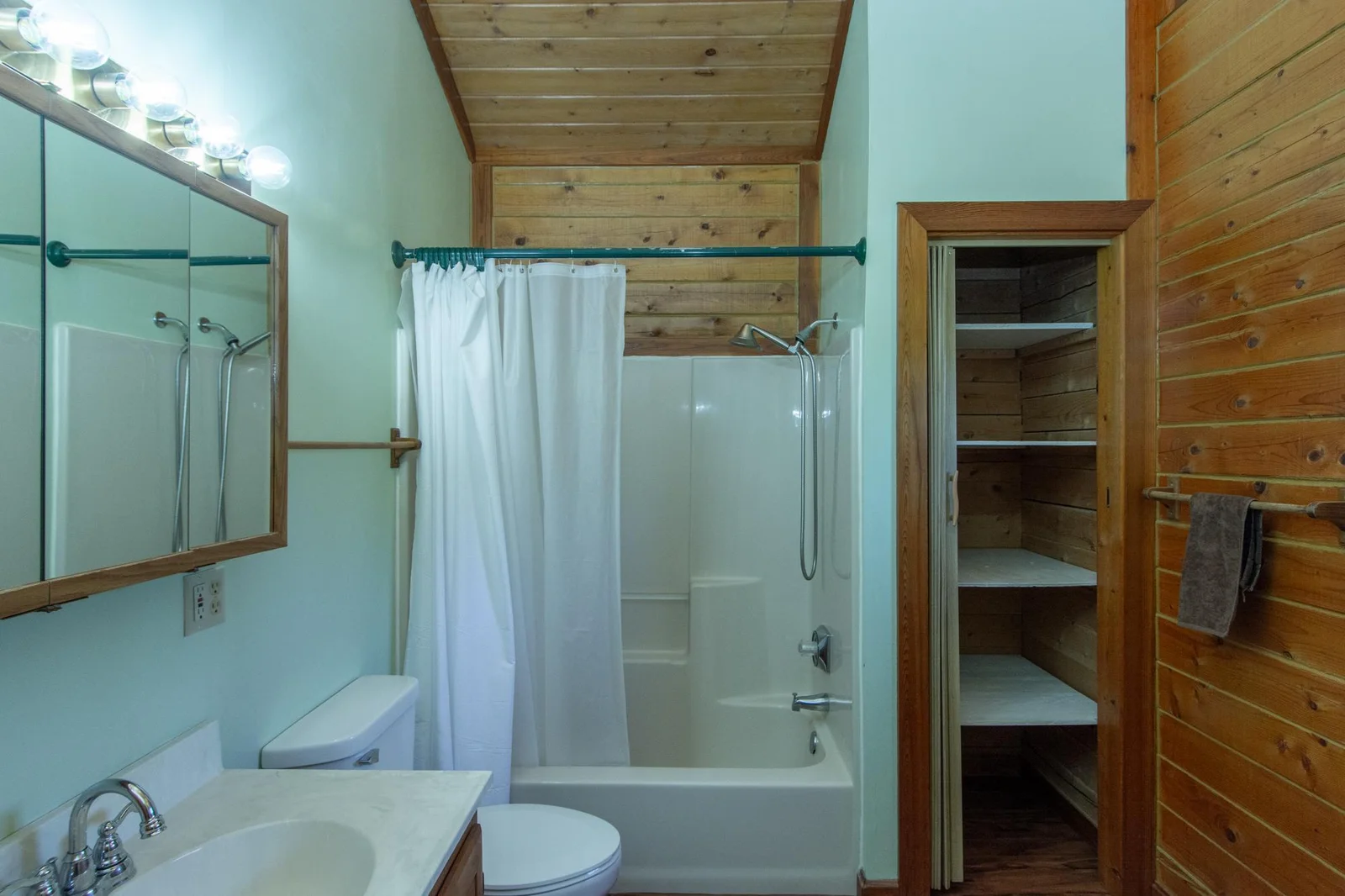 Main floor full bathroom has vinyl floor, a vaulted ceiling, a north-facing window, and a 2x3 ft. closet.