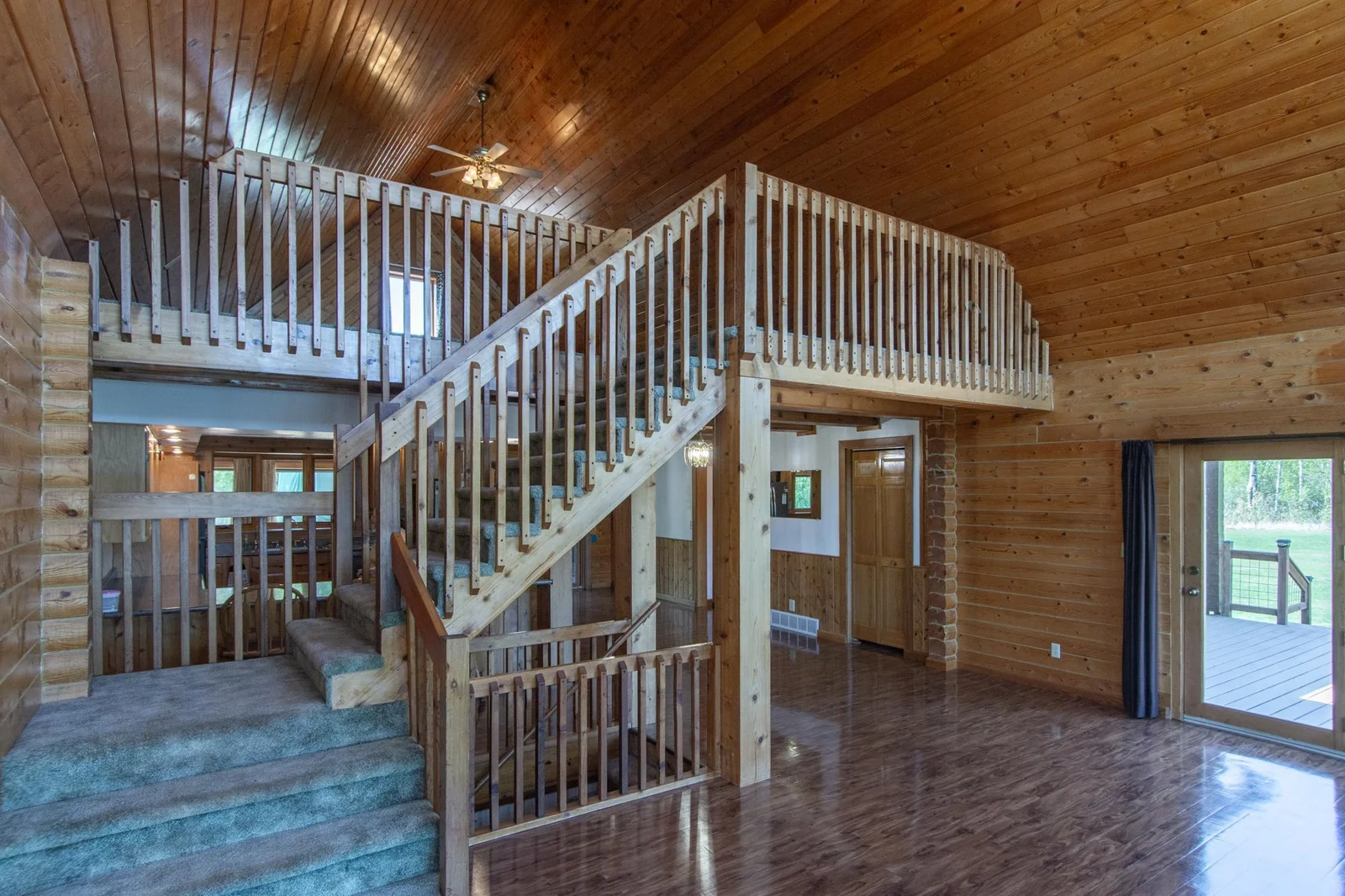 The steps going from the living room to the loft are carpeted. The loft overlooks the yard and pond through the six living room windows.