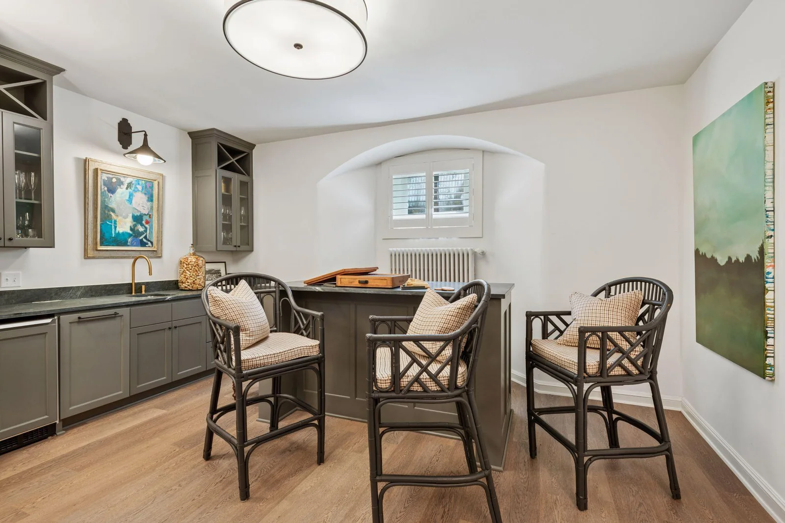 Lower level recreation room with wet bar, sink, ice maker, great counter space and storage for barware.