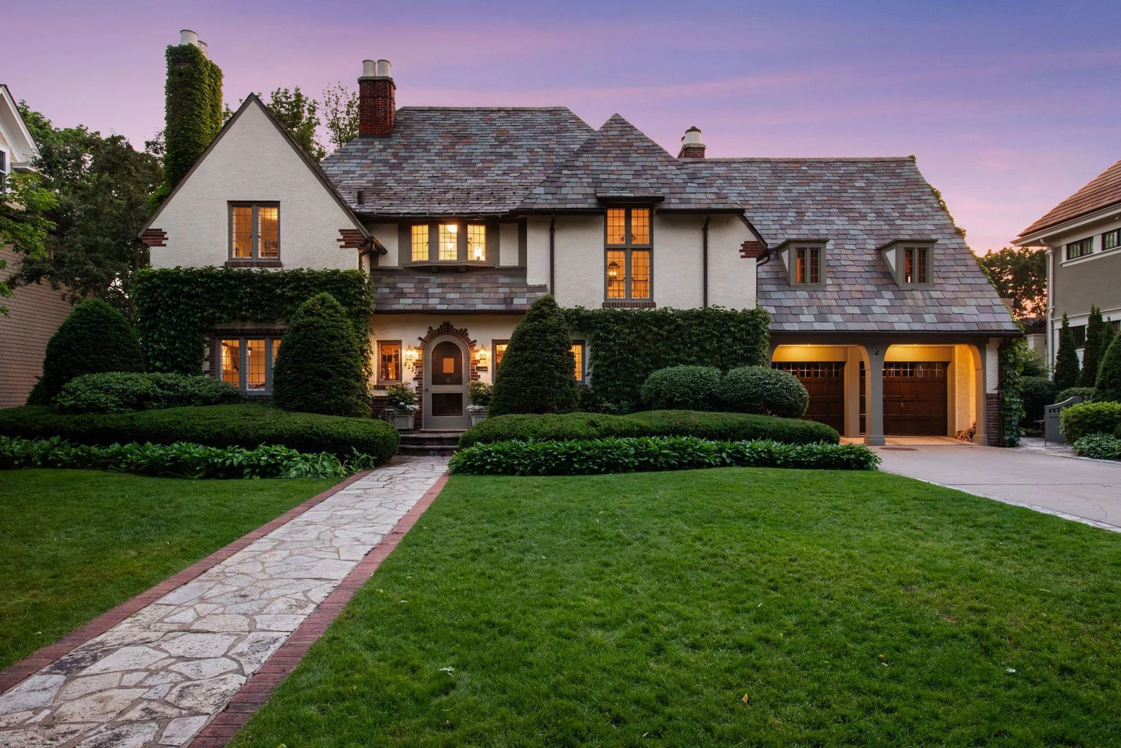 Beautifully manicured gardens and hedges accent the classic Tudor architecture.  Gorgeous slate roof. 2-car attached heated garage, and a wide front lawn.