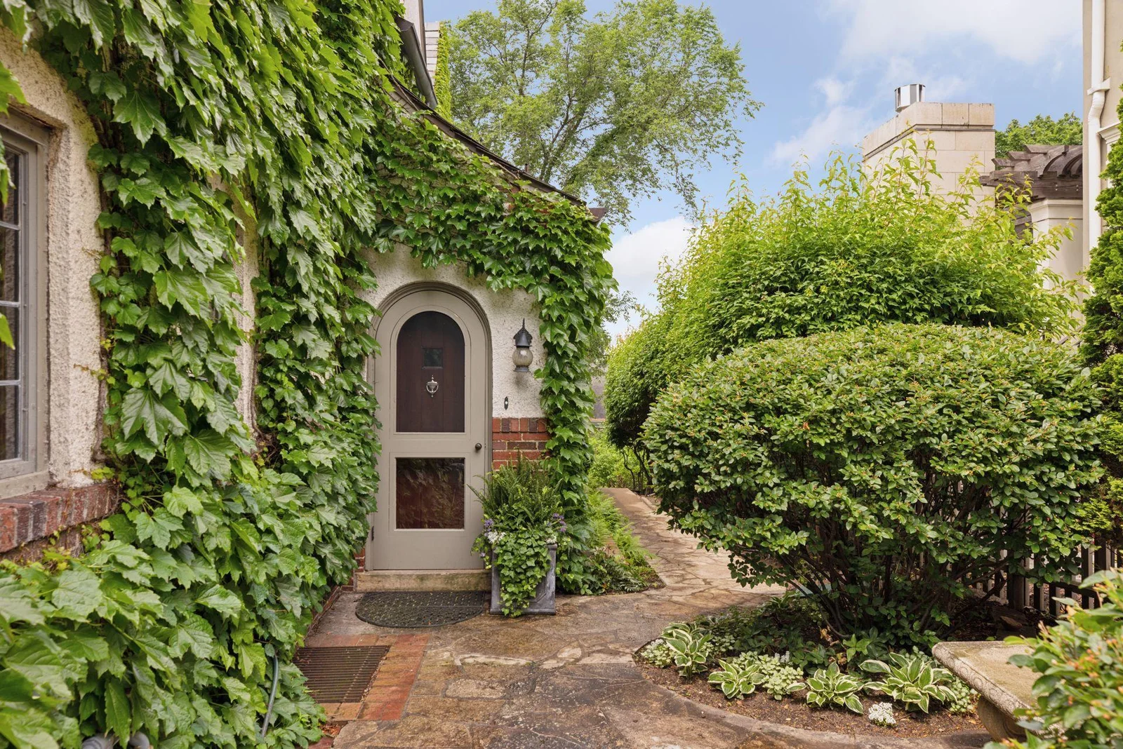 A charming side entrance leads to the mudroom and powder room. Brick paver walkway.  A discreet garden shed is accessible from the north side of the home.
