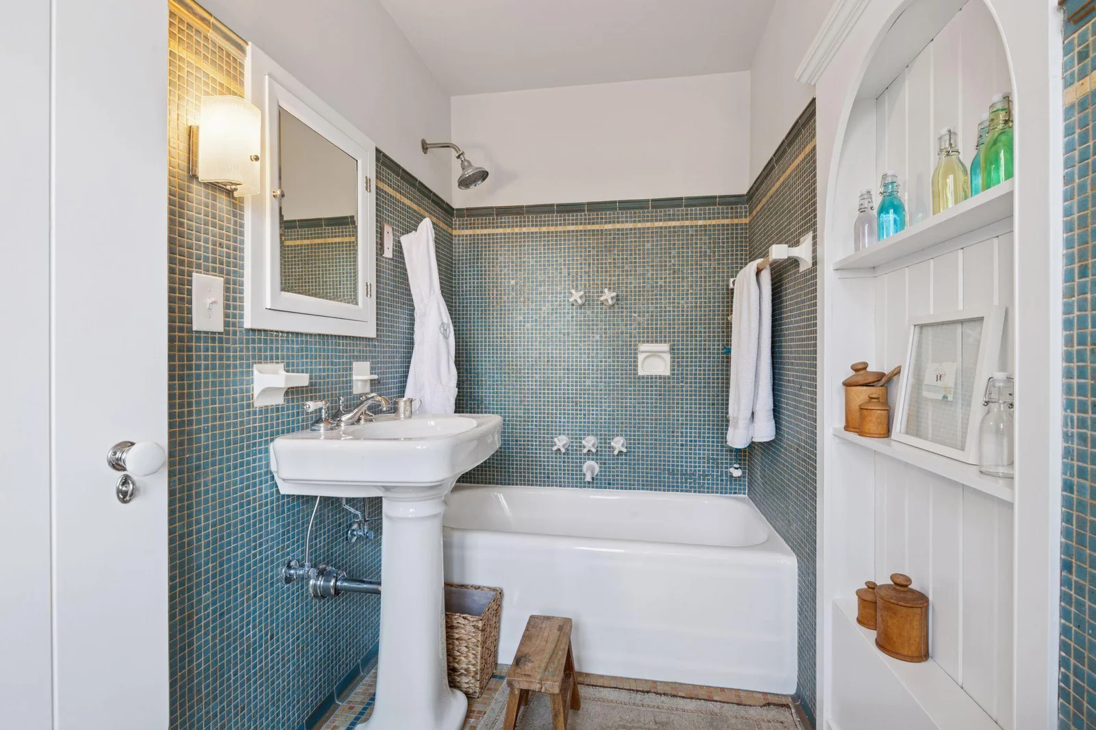 Second bedroom en suite full bath with gorgeous original tile, medicine cabinet, built-in glass, and lovely leaded glass windows to the west.