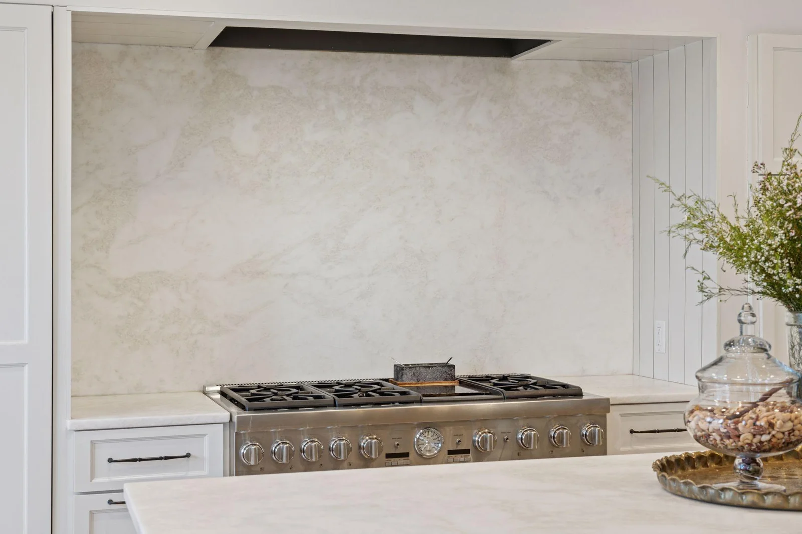 Gorgeous marble counters and backsplash.  Six burner range with double oven. Large integrated exhaust hood.
