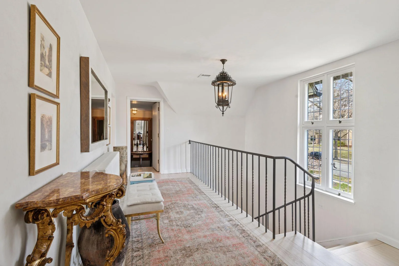Elegant staircase to upper level with east-facing leaded glass windows.