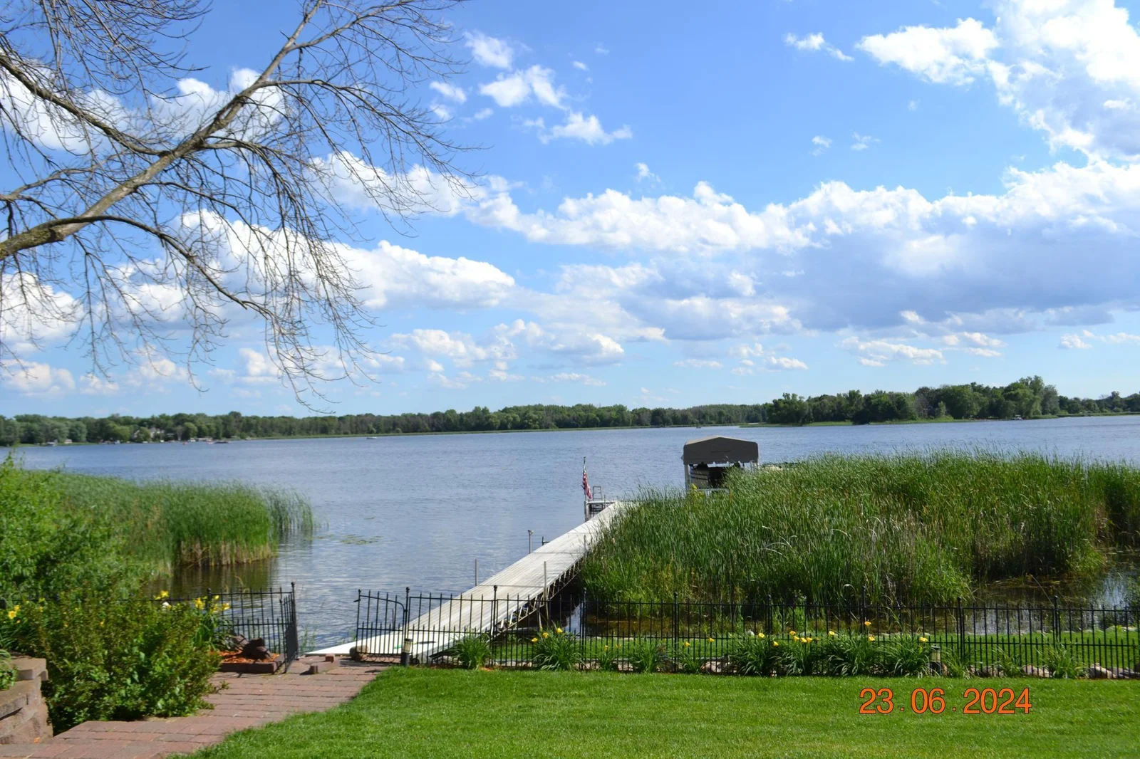 Expansive 124 foot dock surrounded by well maintained garden beds and lawn