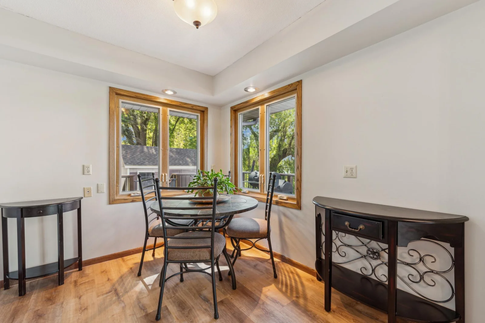Cozy informal dining area surrounded by windows, offering a perfect spot for morning coffee with serene outdoor views.