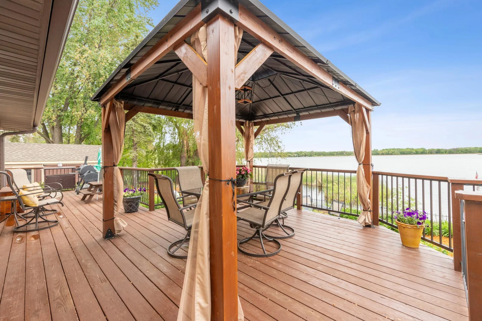 Expansive deck overlooking the spacious patio and lake