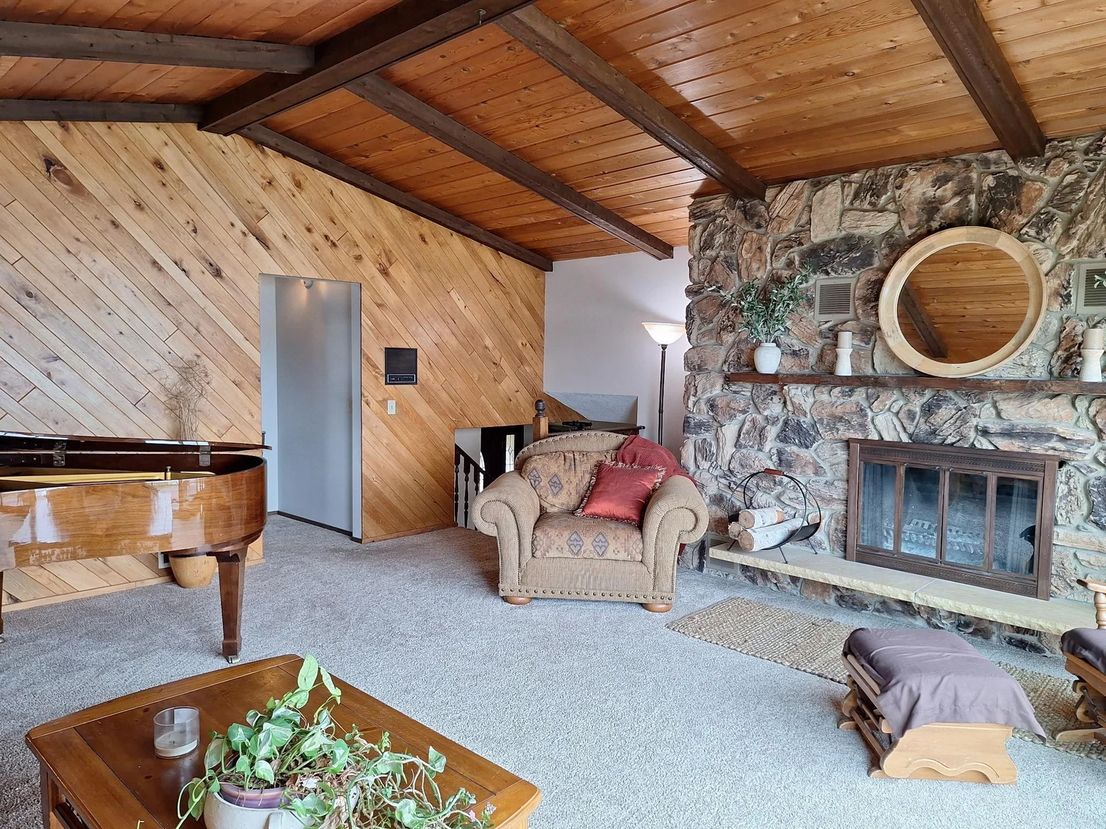 Upper level living room with plush carpet, vaulted ceilings and a cozy floor to ceiling stone fireplace.