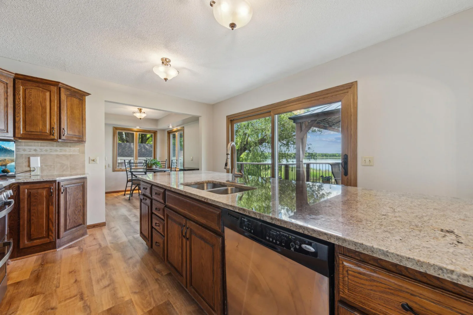 Bright kitchen and dining flow seamlessly into the outdoor deck area, offering an ideal space for entertaining with lake views.