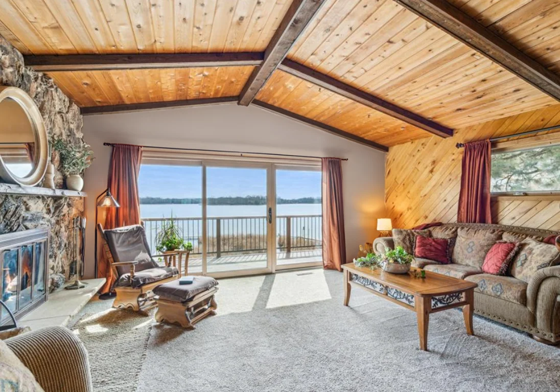 Upper level living room with panoramic views of the lake and walk out access to the large deck