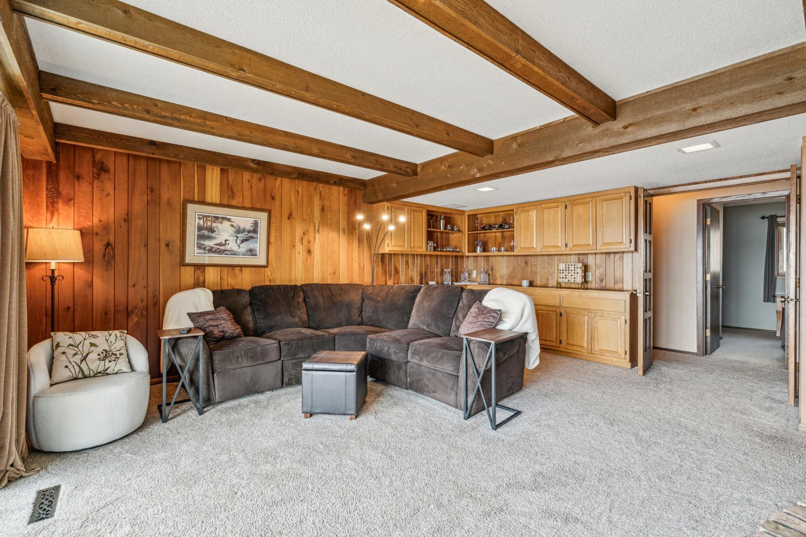 Lower level family room with elegant wood beams and a cozy wood burning stove