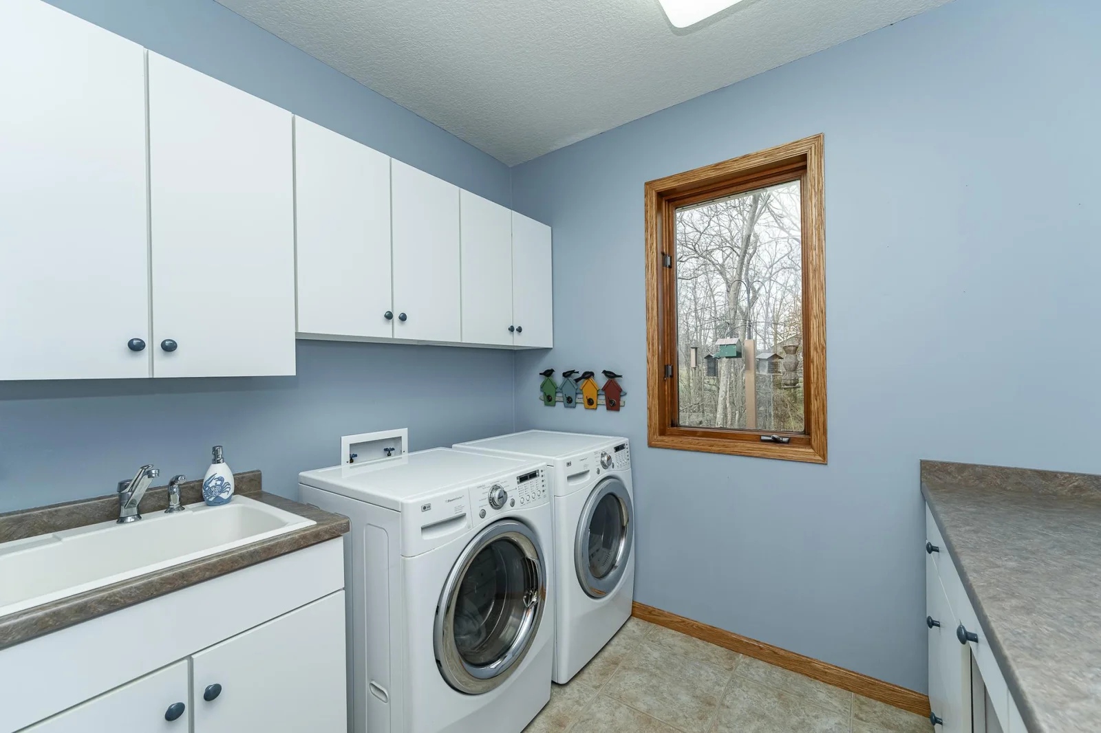 Main floor laundry with sink, storage and work space.