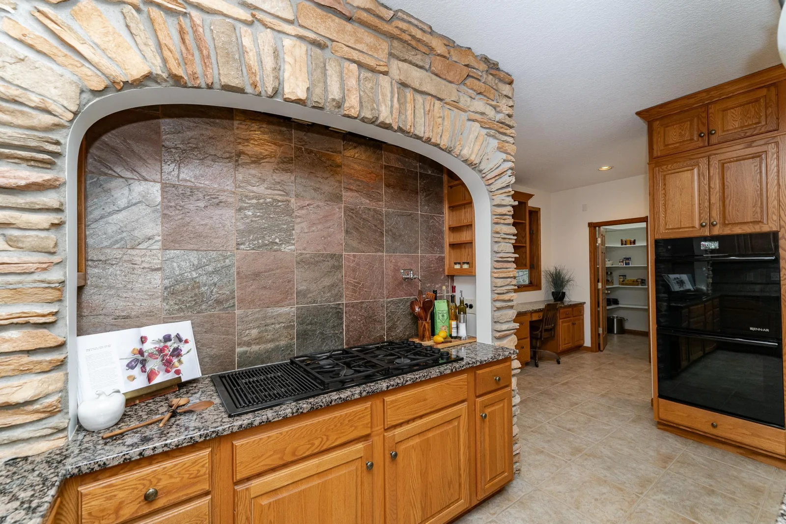 Grill and cooktop with stone alcove.