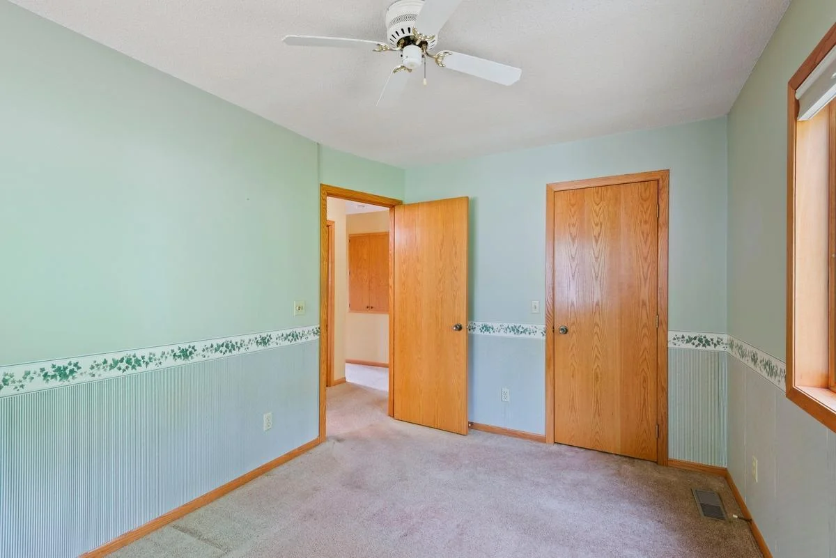 The second main floor bedroom features a walk-in closet, with a large storage closet located just across the hall and an additional storage cabinet above the stairwell.