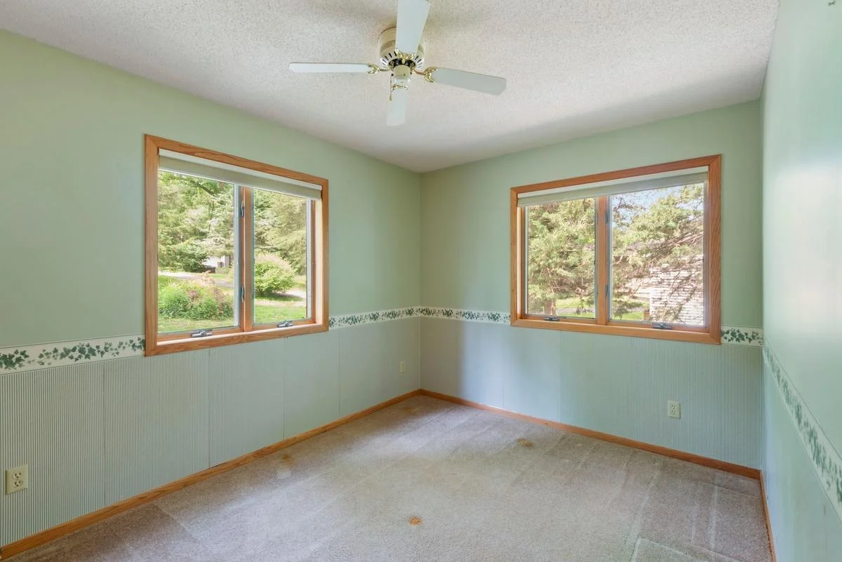 The second main floor bedroom is conveniently located adjacent to the bathroom, offering flexibility for guests or a home office.