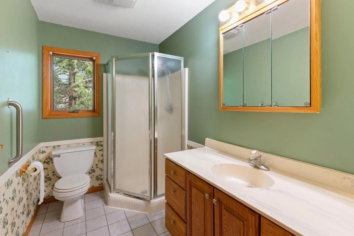 The main floor bathroom offers a functional and comfortable layout, featuring durable flooring and a large vanity with generous storage space.