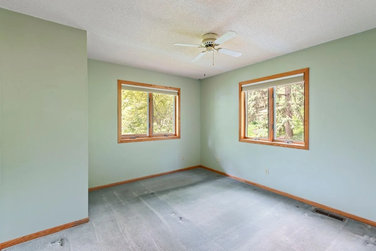 The primary main floor bedroom offers peaceful backyard views.