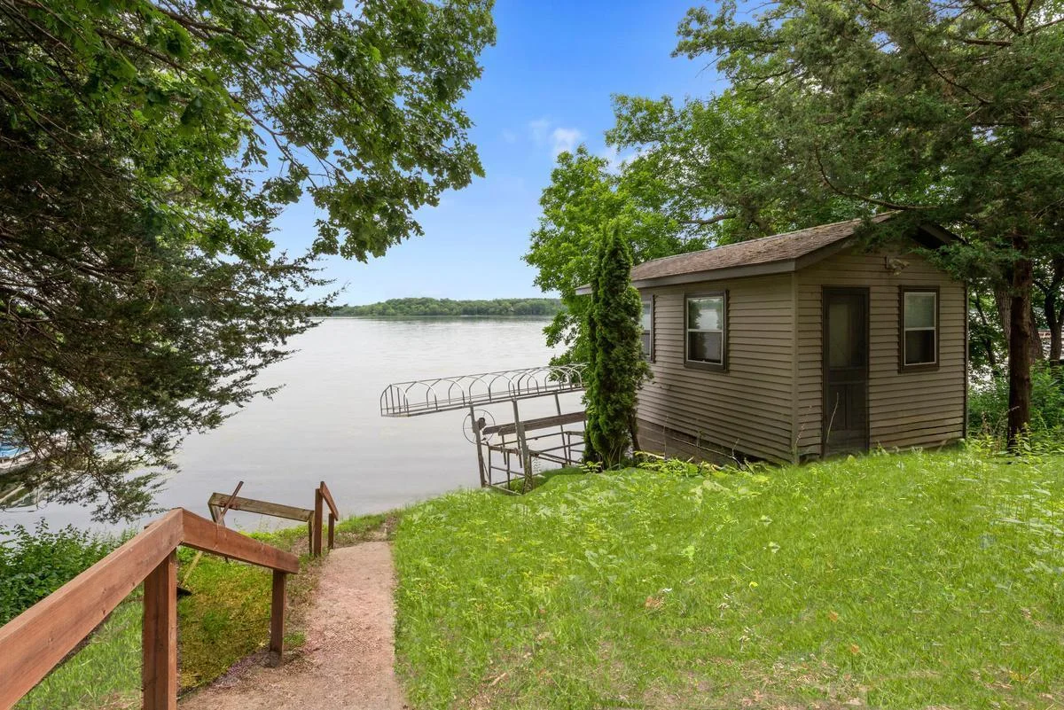Just steps from the shoreline, a charming lakeside bunkhouse offers additional space for guests, lake toys, or extra storage.