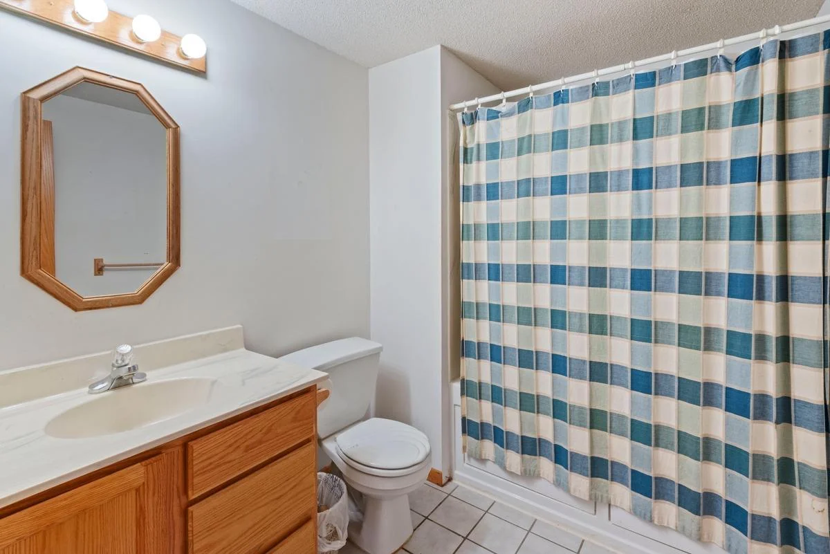 The lower-level bathroom is conveniently located just off the family room and features tile flooring, and a spacious vanity—perfect for guests or everyday use.