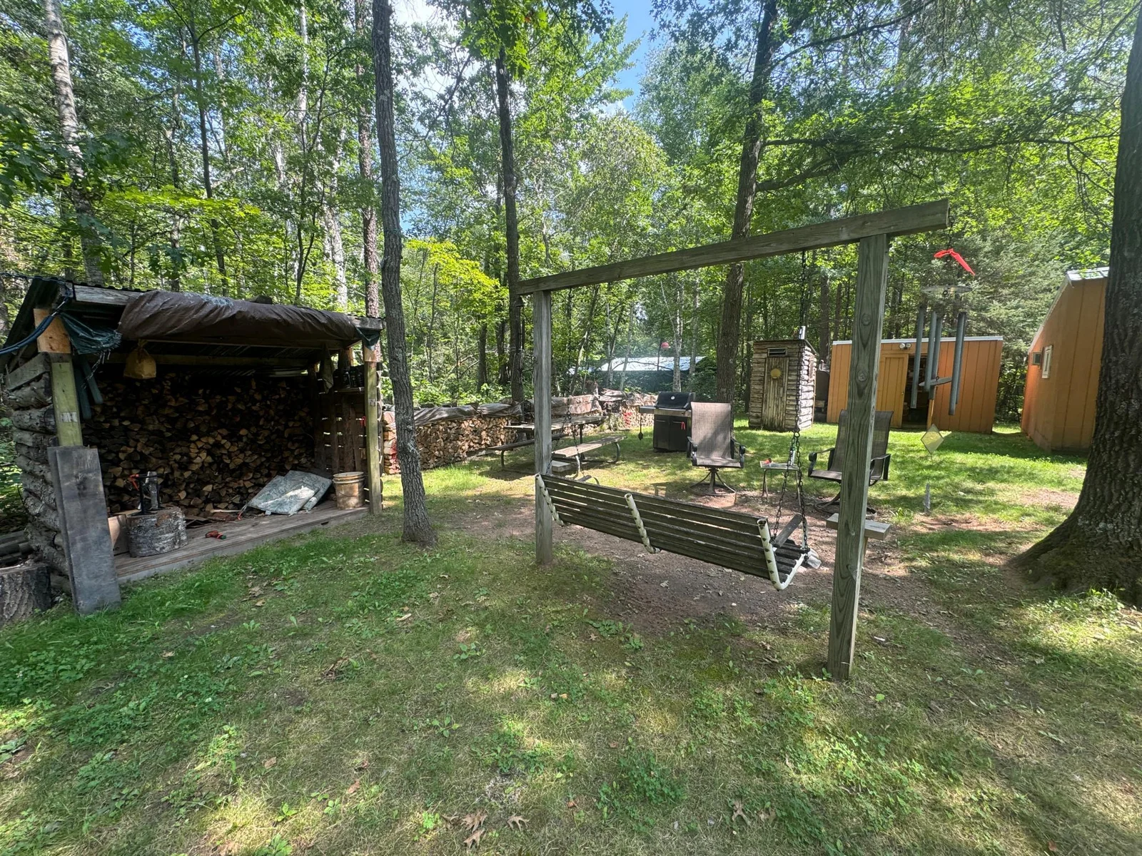 Wood storage shed near fire pit.