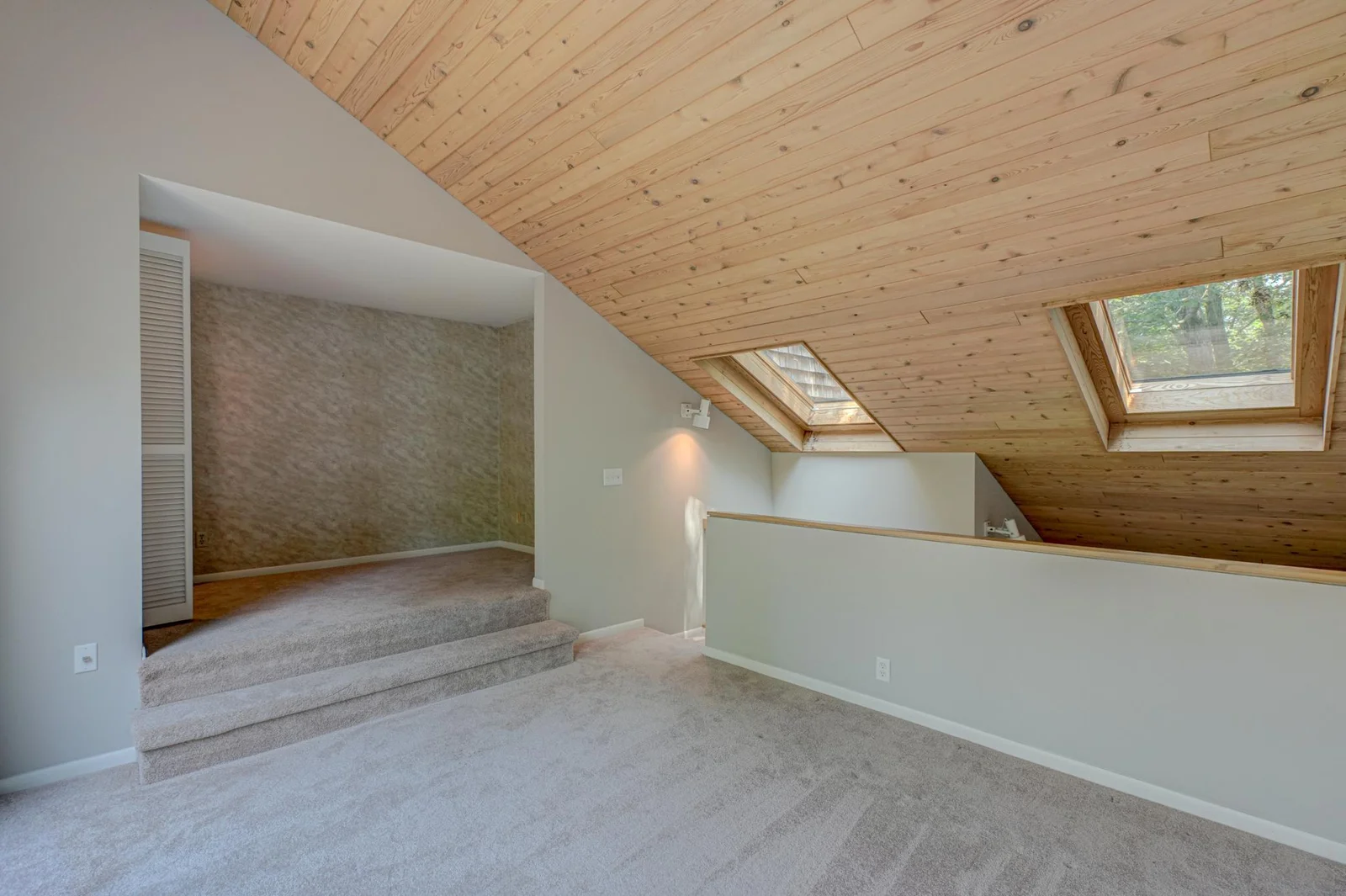 The upper levels offering generous bedrooms, including a loft with a balcony overlooking the river, are open to the levels below, creating an airy, connected feel from floor to floor.