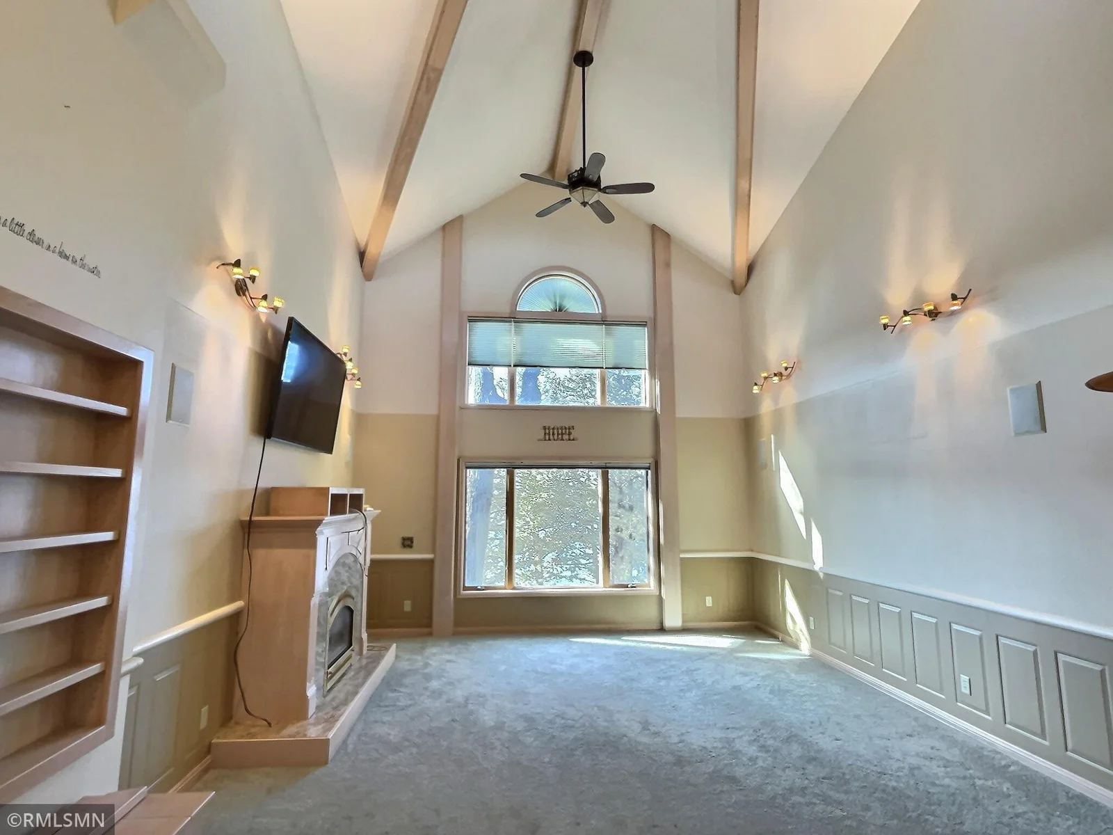 This beautiful formal living area provides a beautiful fireplace, grand vaulted ceiling, and great view to the lake.