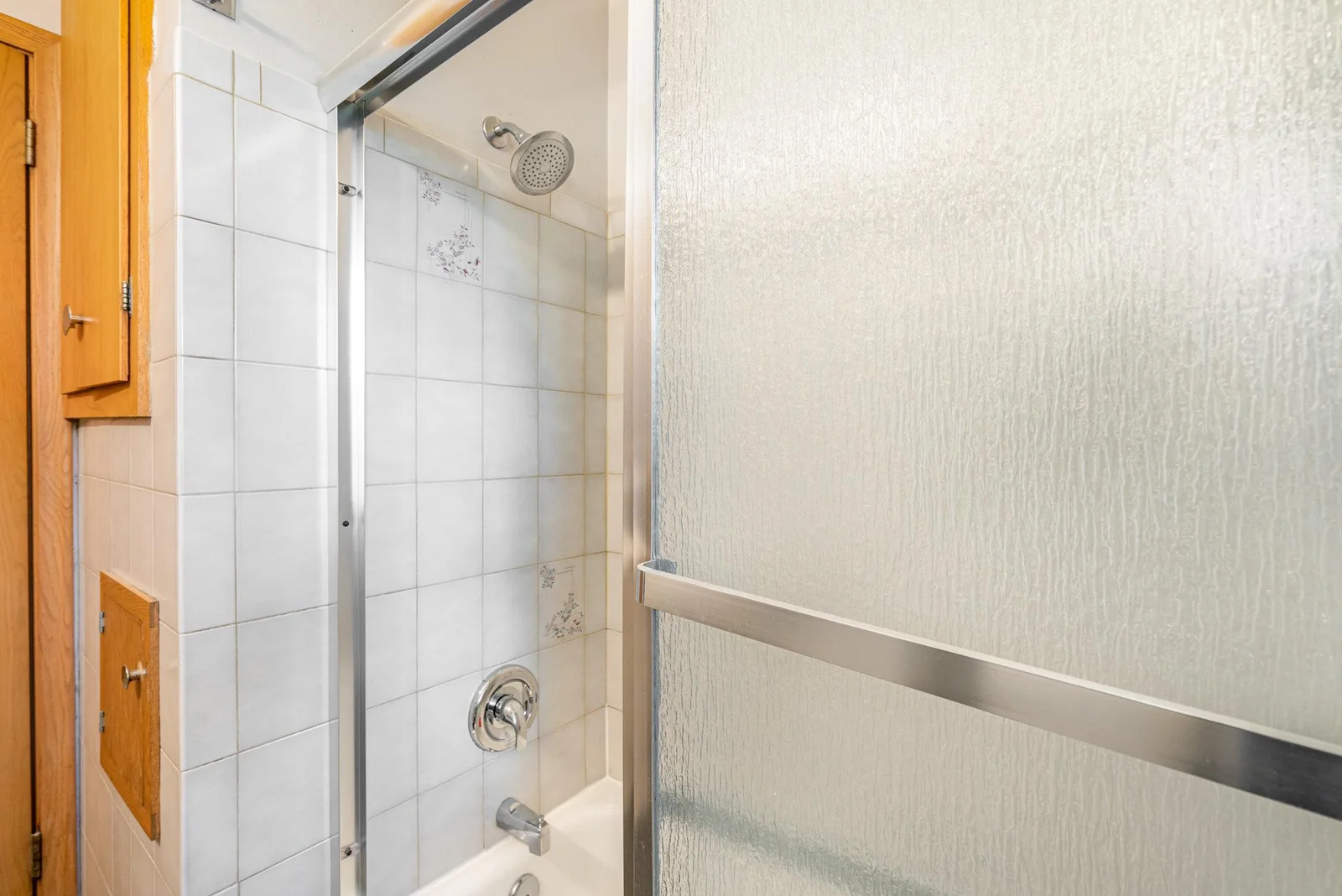 Main level shower with neutral ceramic tiling